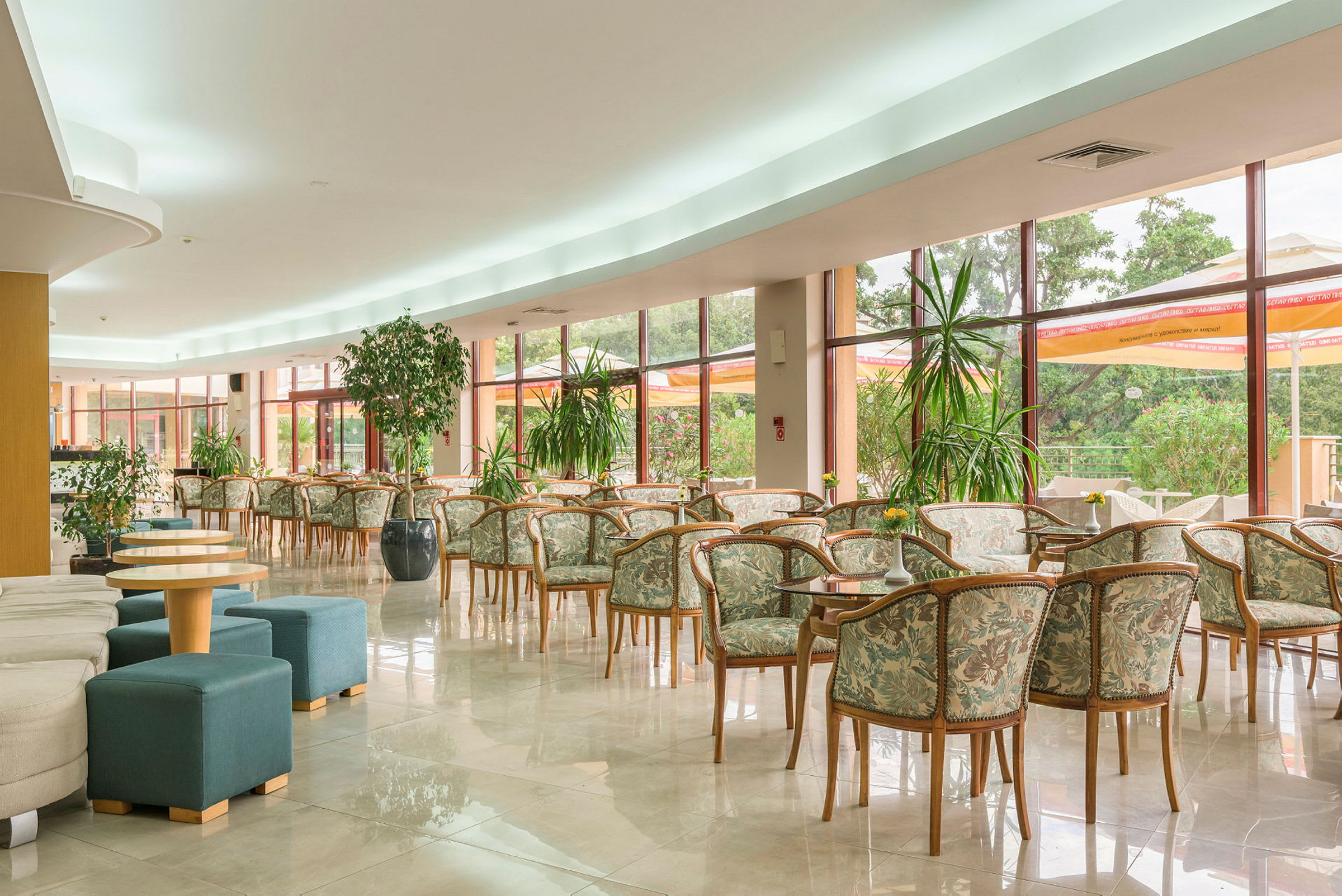 En rymlig lounge med många stolar och bord framför stora fönster. (AI-genererad text)