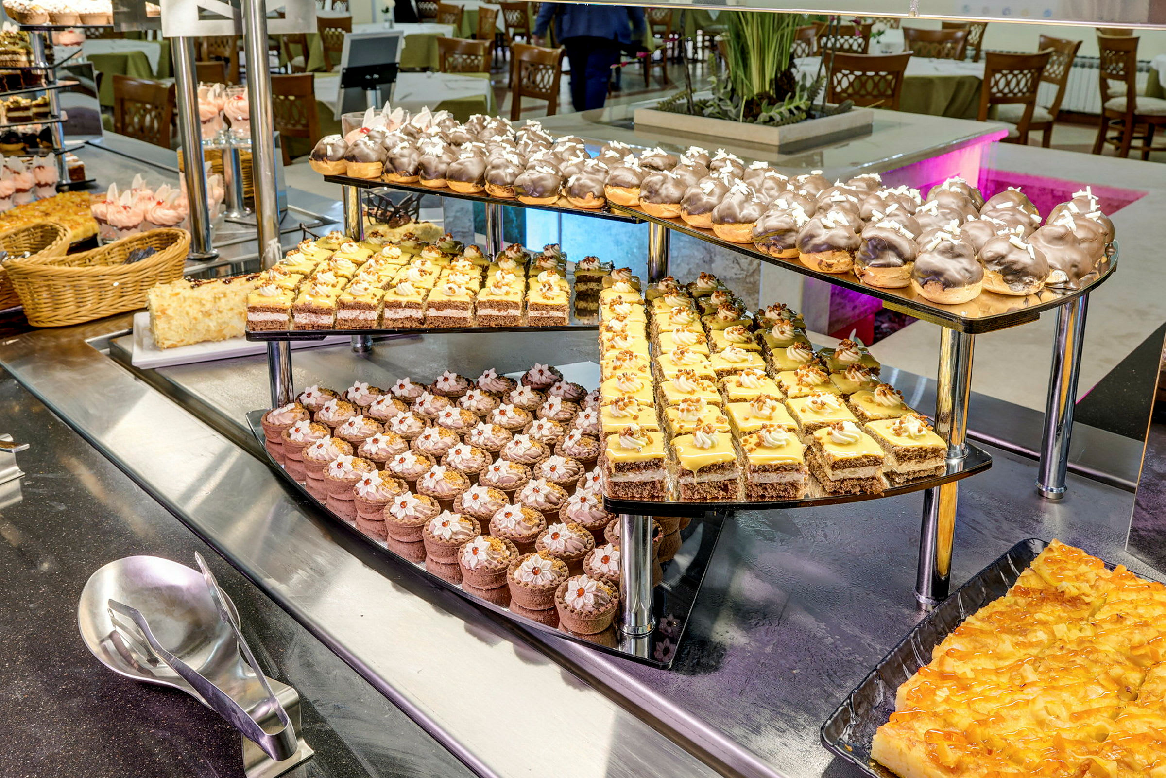 Ett dessertbord med ett urval av olika bakverk och kakor på ett uppläggningsstativ. (AI-genererad text)
