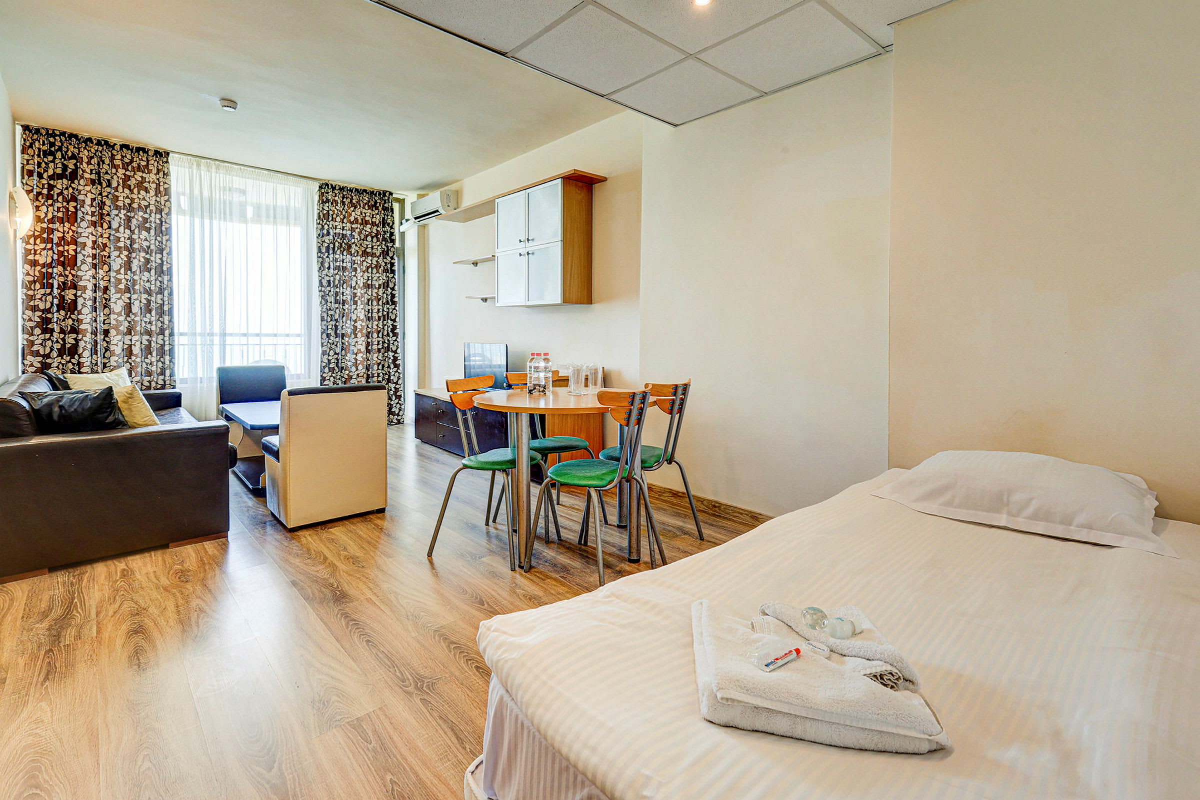 Ett hotellrum med säng, matbord och sittgrupp. (AI-genererad text)