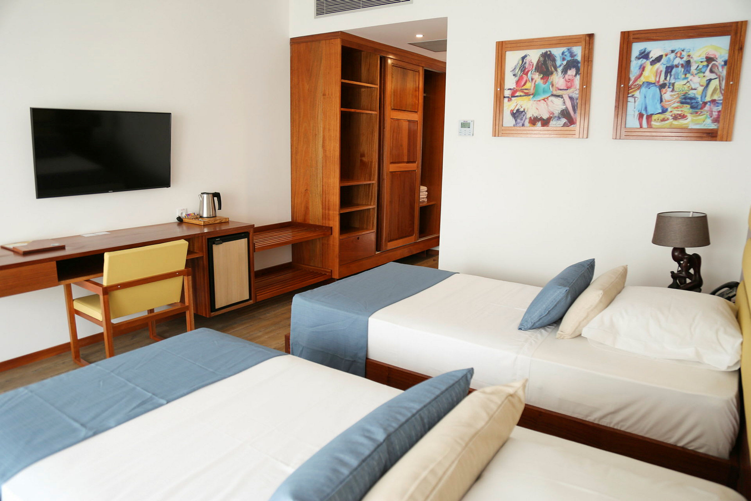 Hotellrum med två enkelsängar, träinredning och möbler. (AI-genererad text)