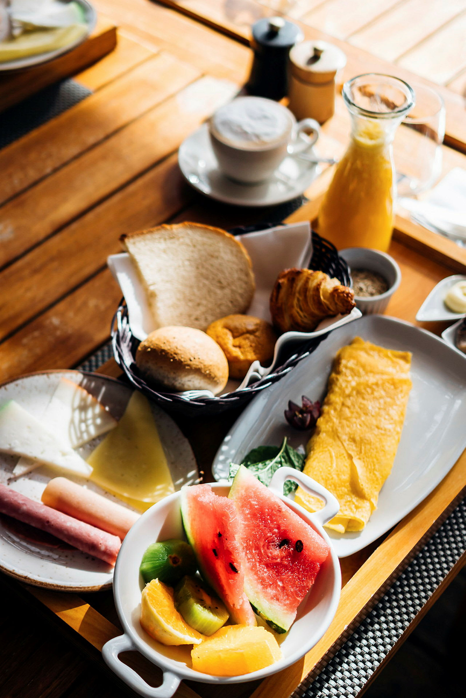 En frukostbricka med omelett, frukt, bröd och kaffe. (AI-genererad text)