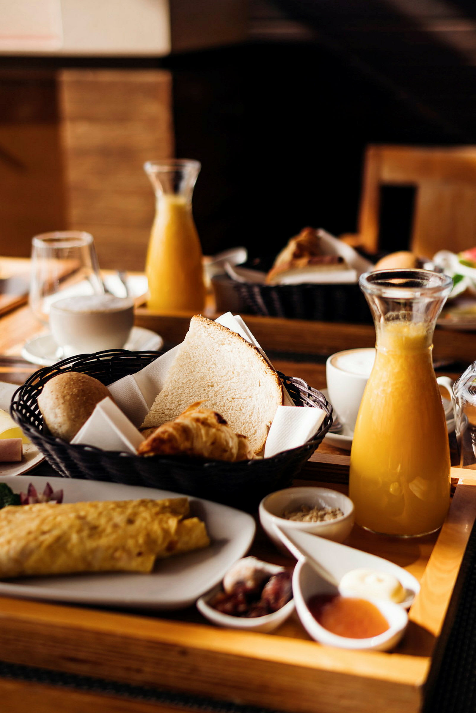 Bild av en frukost med bröd, croissanter, juice och kaffe. (AI-genererad text)