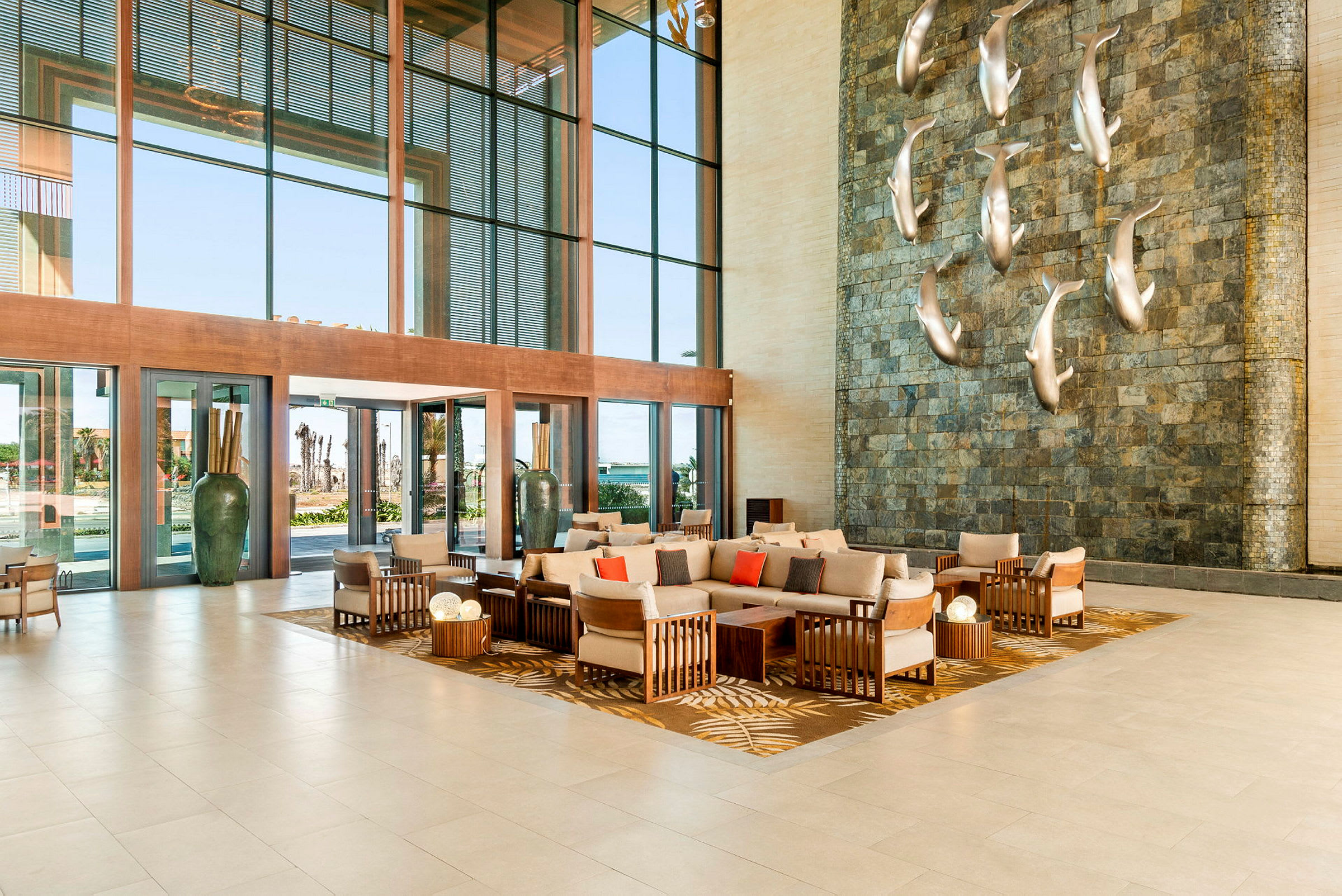 Bild av en hotellobby med moderna möbler och en dekorativ vägg med silverfiskar. (AI-genererad text)