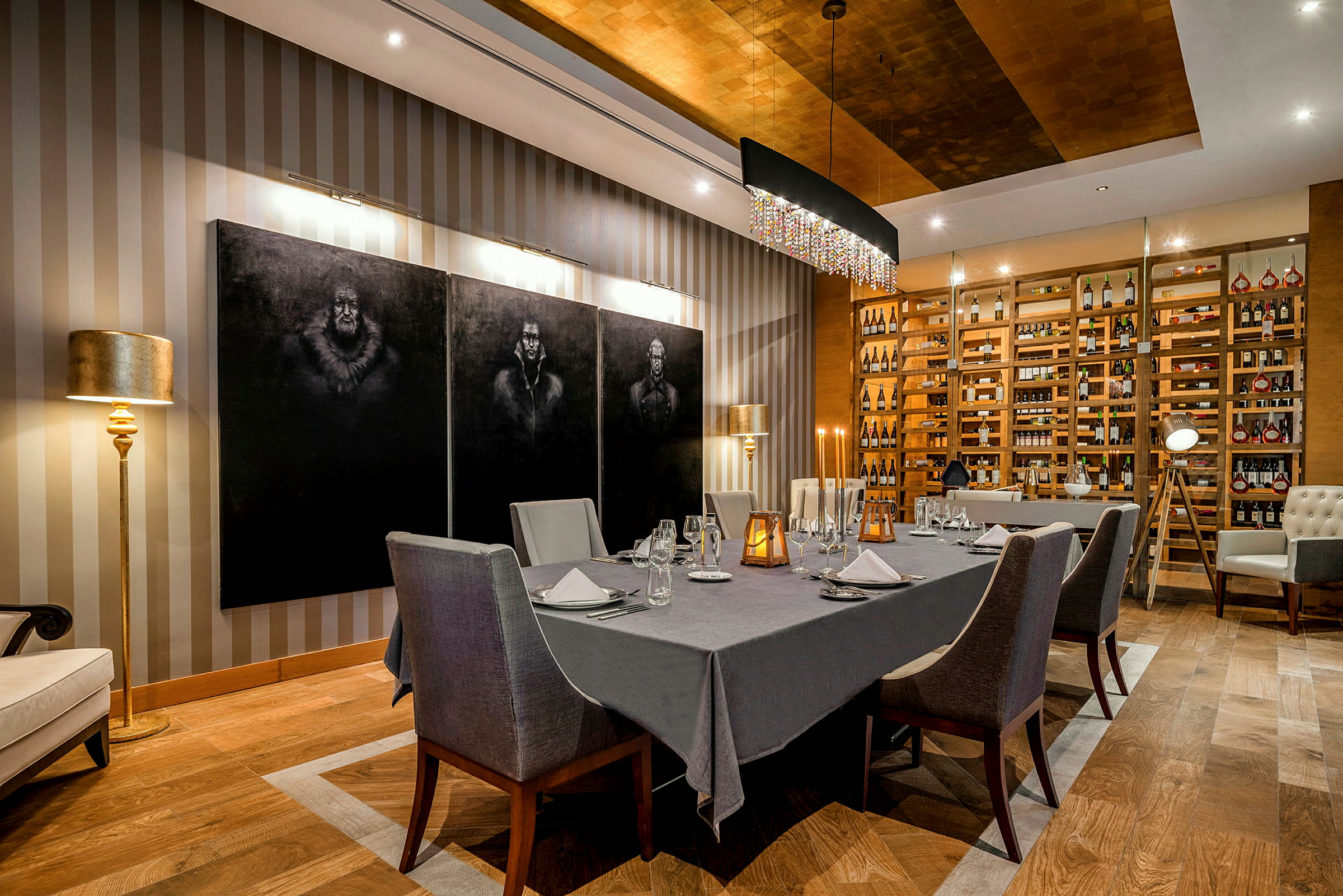 En elegant matsal med dukat bord, stolar och stilfull inredning med målningar och vinförvaring. (AI-genererad text)