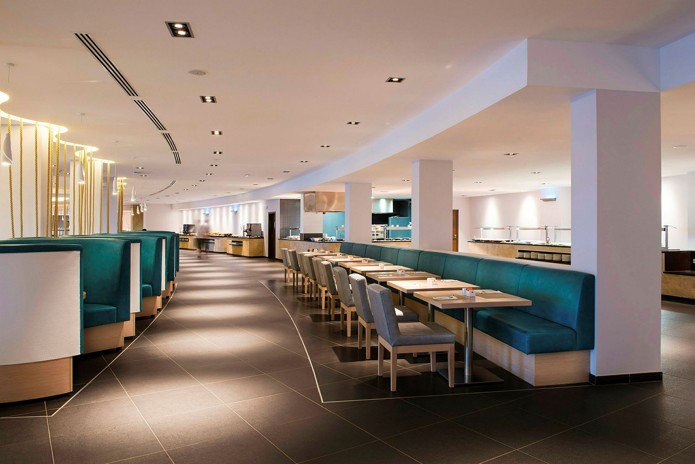 Bild av en modern restaurangmiljö med bord, stolar och bänkar. (AI-genererad text)