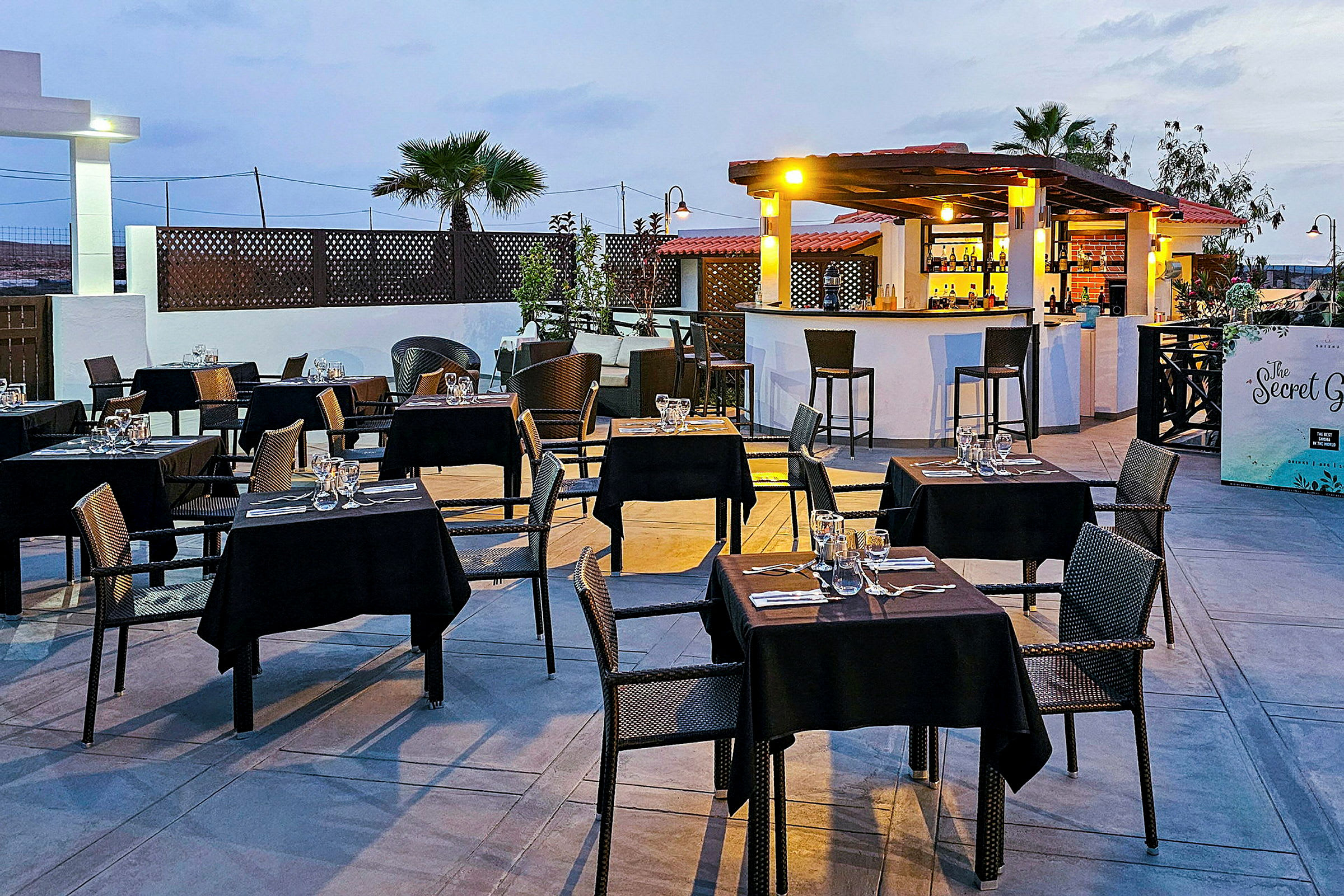 Utomhusrestaurang med dukade bord och en bar. (AI-genererad text)