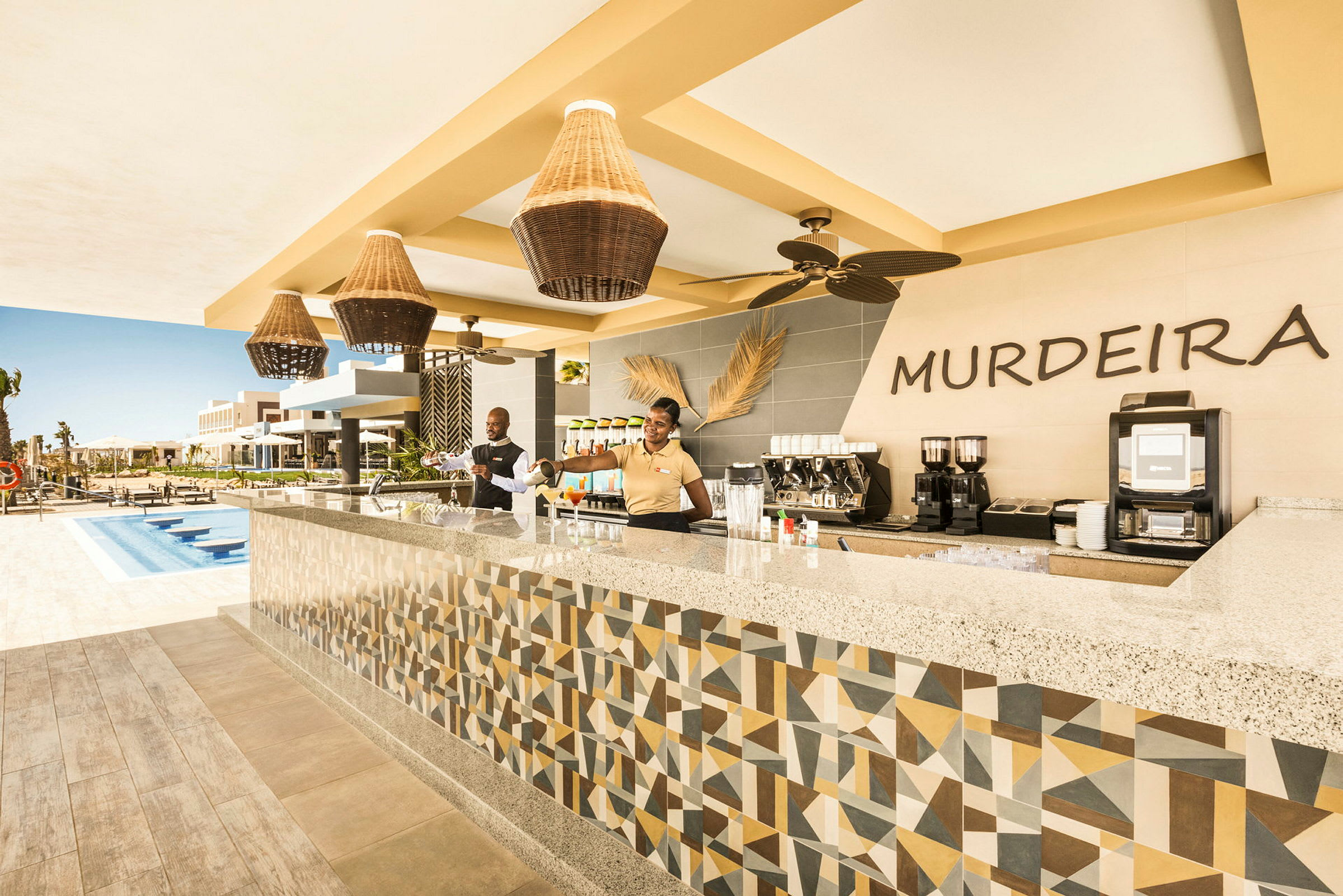 En poolbar vid en semesterort med utsmyckad design och pergolabelysning. (AI-genererad text)