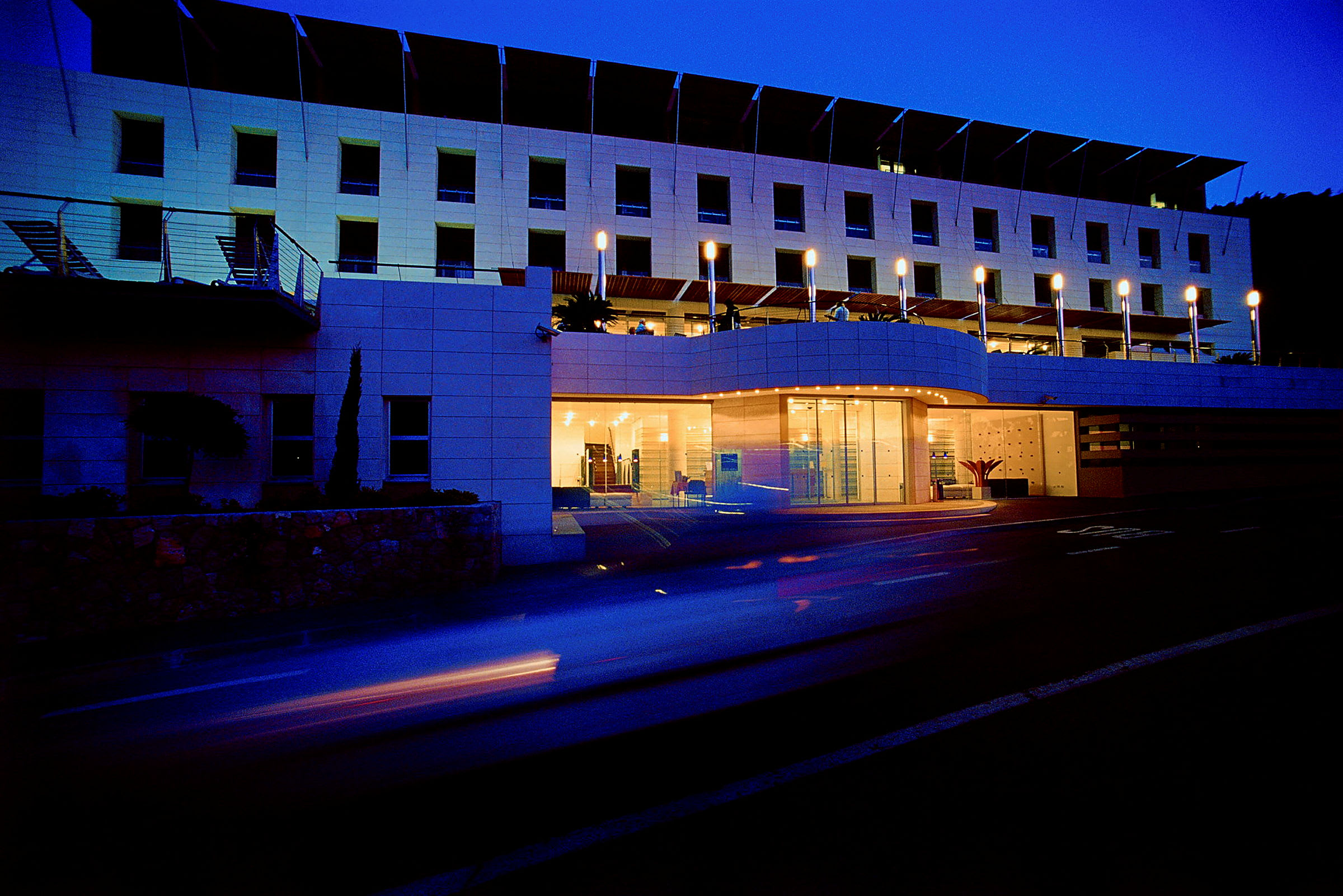 Hotellfasad belyst i skymningen. (AI-genererad text)