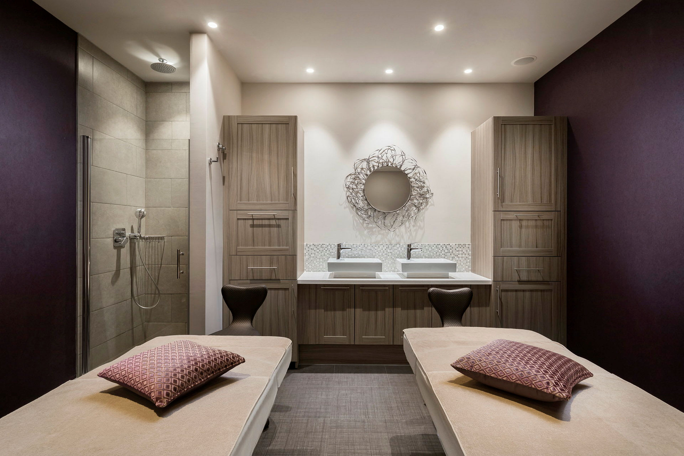 Ett spa-rum med två massagebänkar och en dusch. (AI-genererad text)