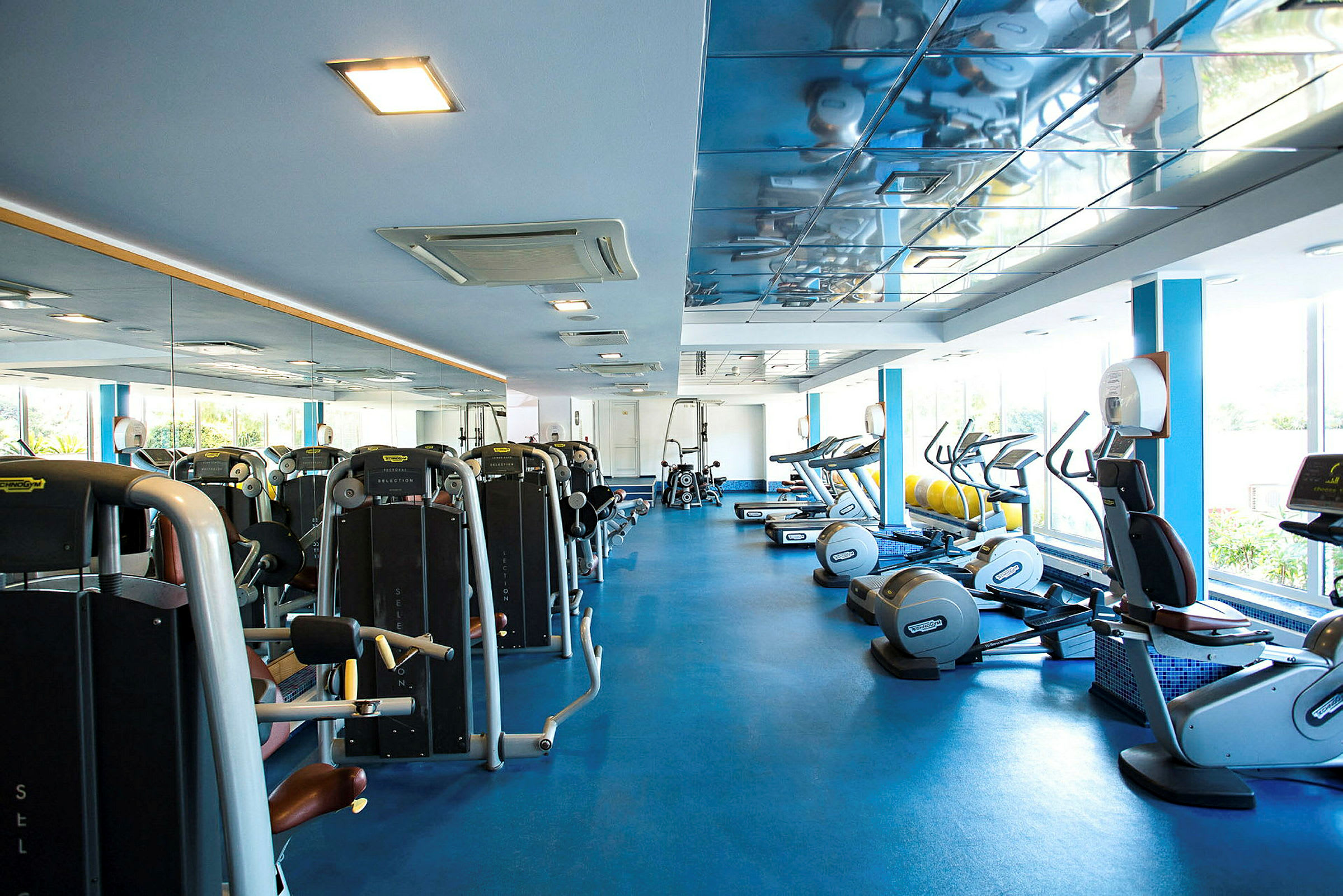 Bild av ett gym med träningsmaskiner och speglar. (AI-genererad text)
