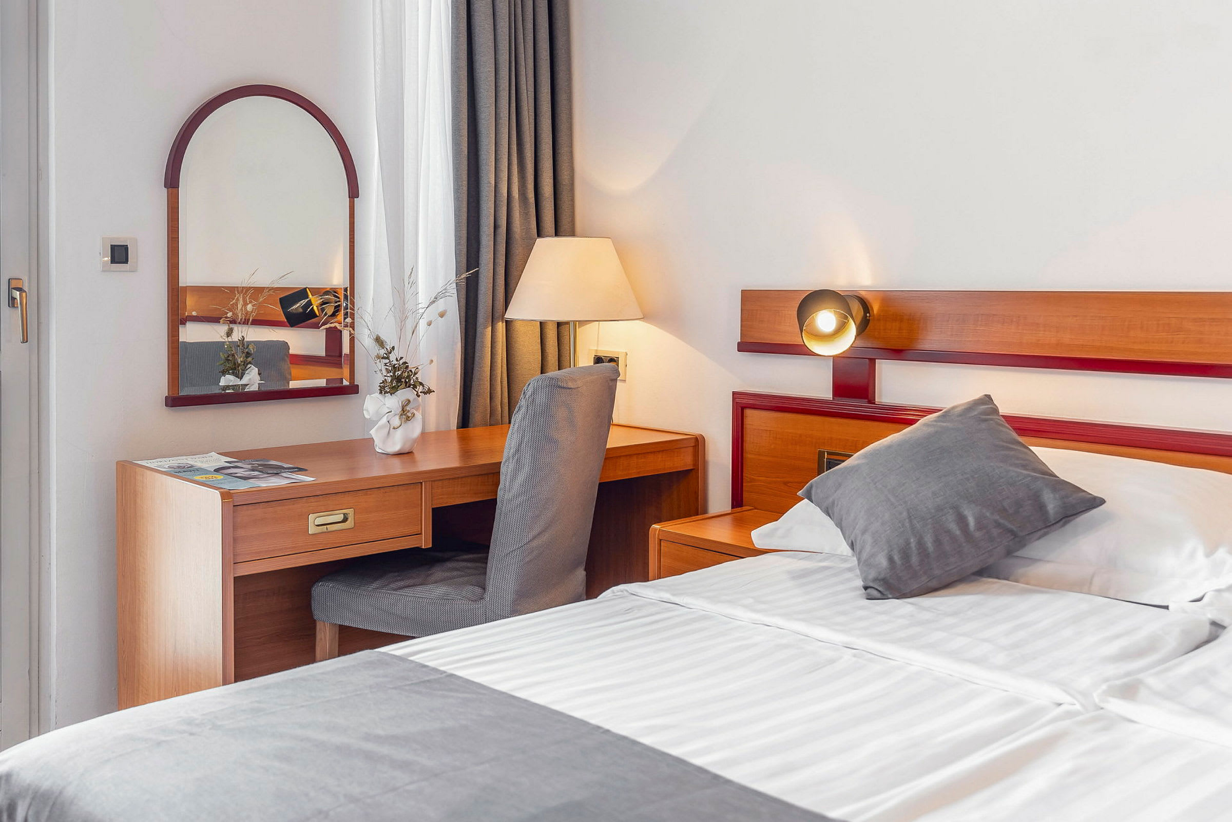 Hotellrum med säng och skrivbord. (AI-genererad text)
