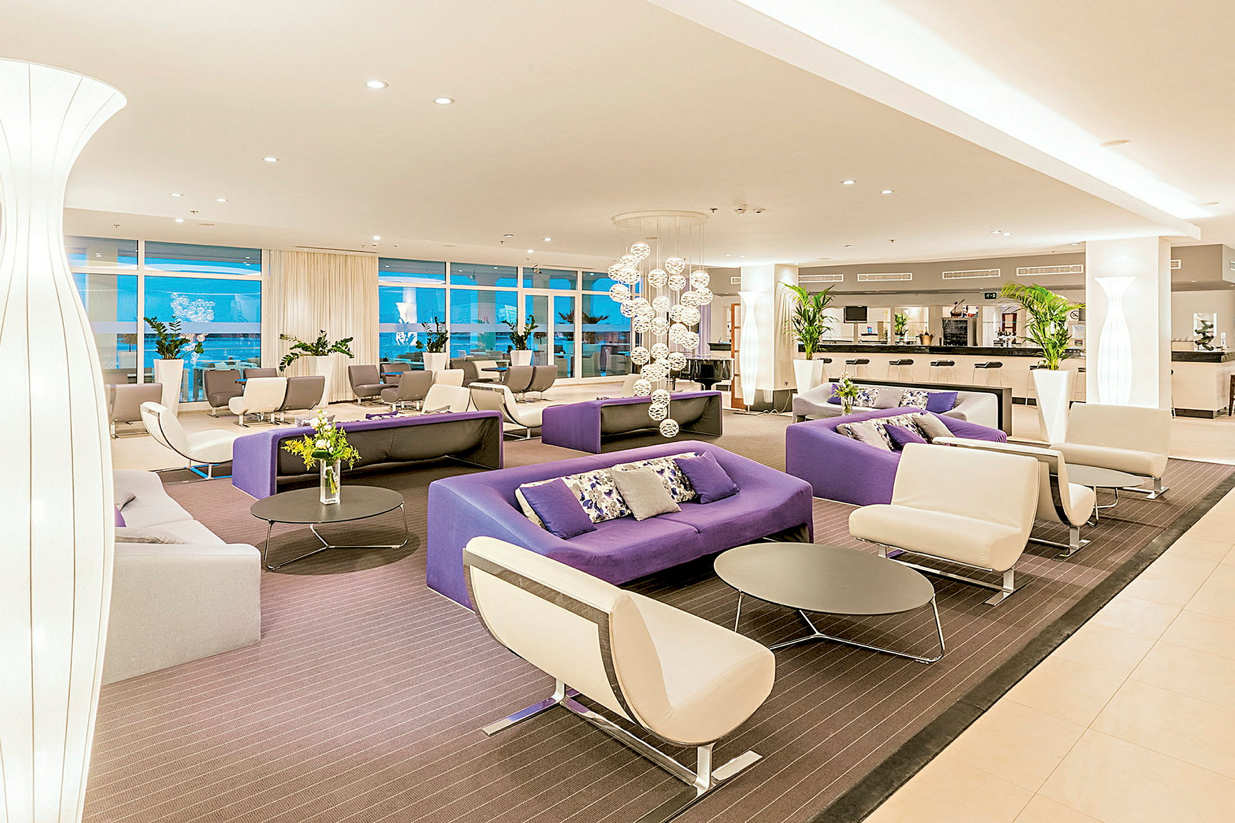 En elegant lobby med moderna möbler i ljusa och lila toner. (AI-genererad text)