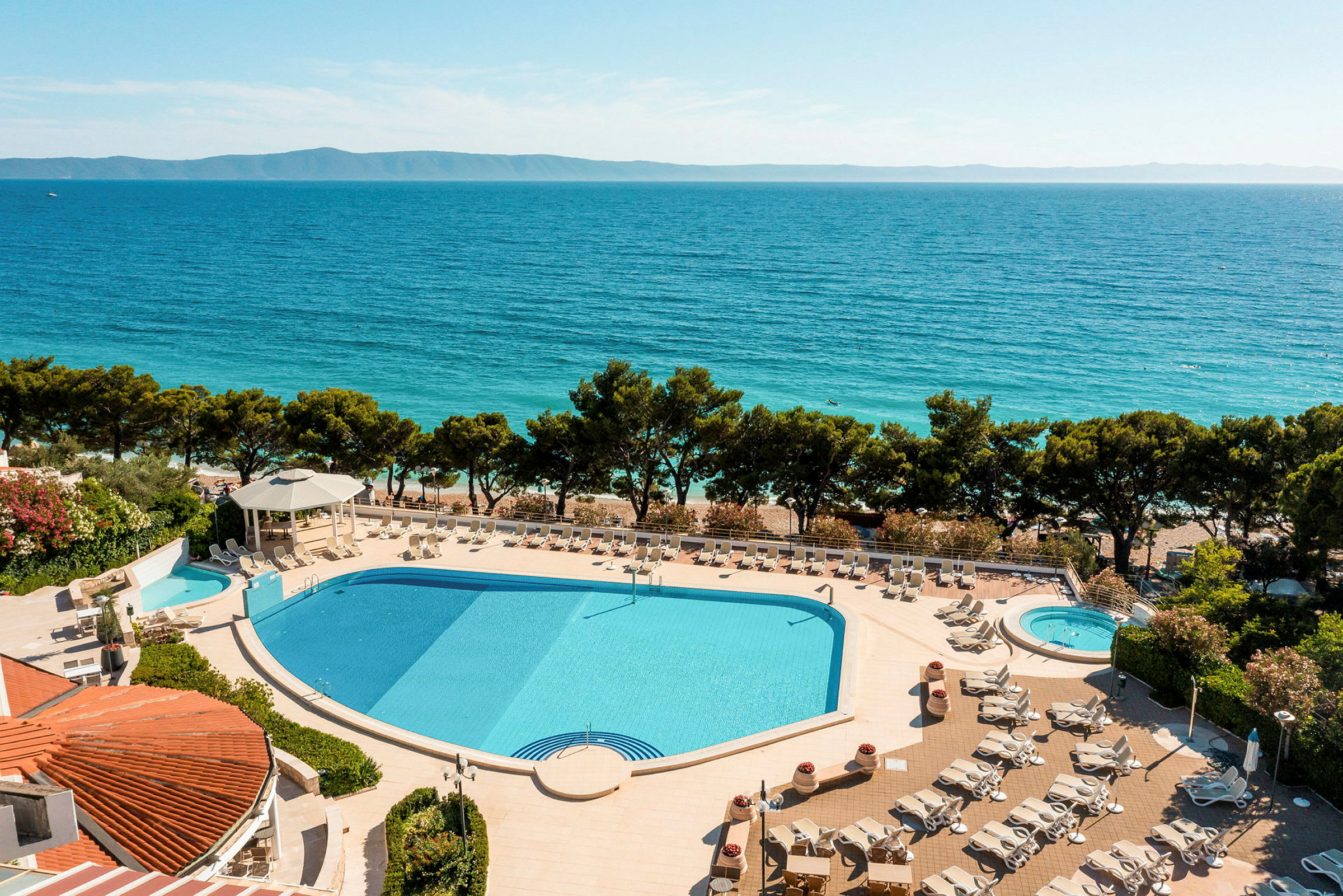 En pool och solstolar vid havet. (AI-genererad text)