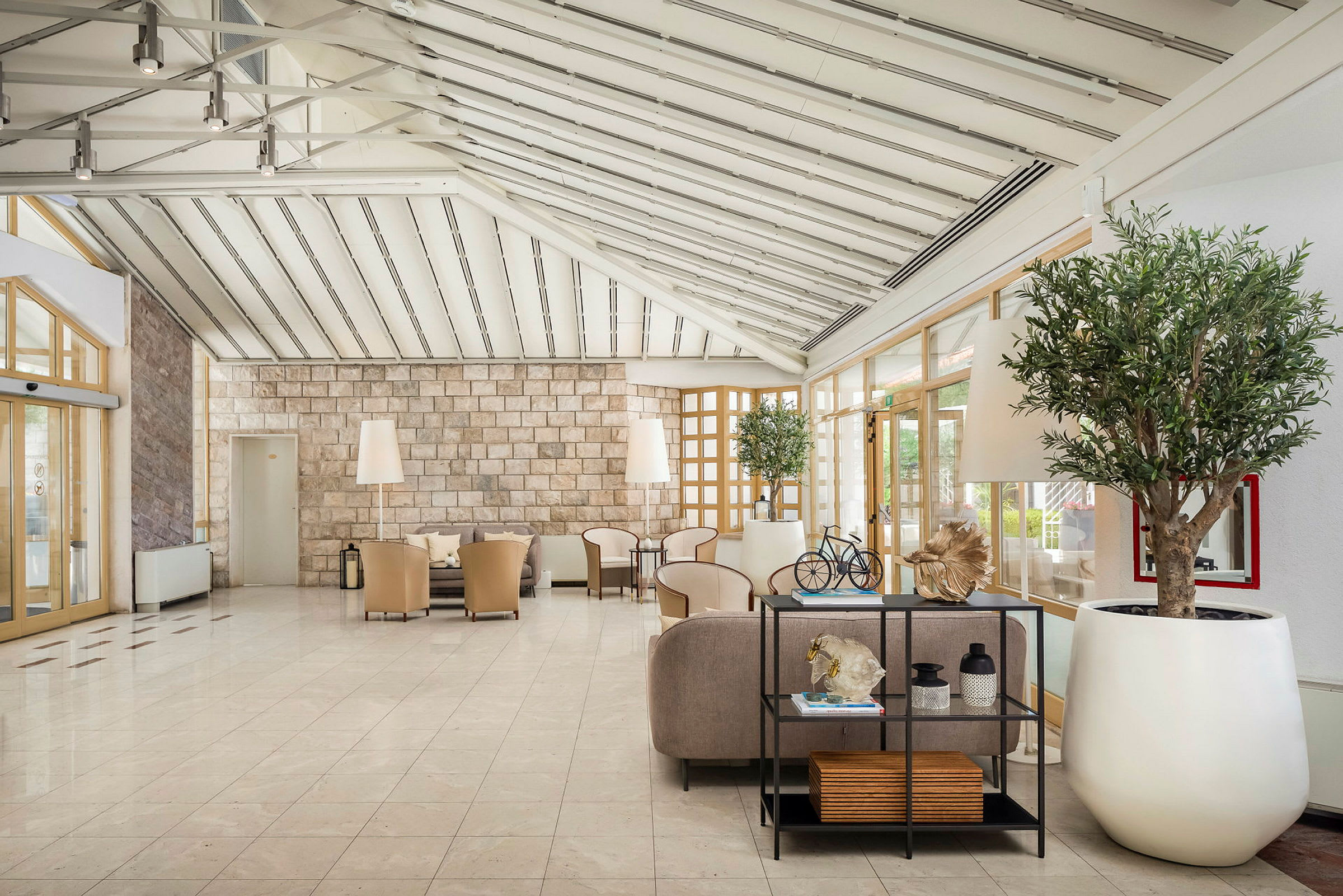 Ljust och rymligt hotelllobby med sittgrupper och dekorativa växter. (AI-genererad text)
