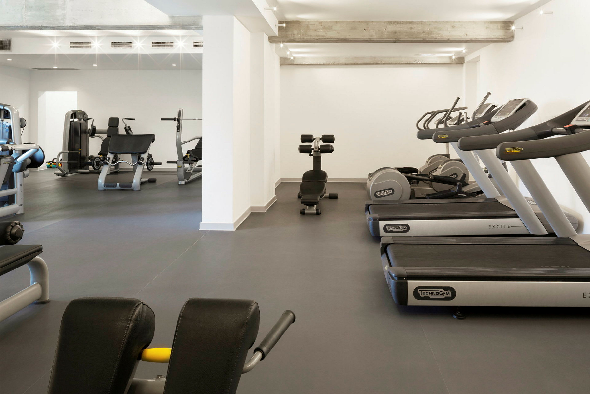 Ett gym med träningsutrustning inklusive löpband och styrketräningsmaskiner. (AI-genererad text)