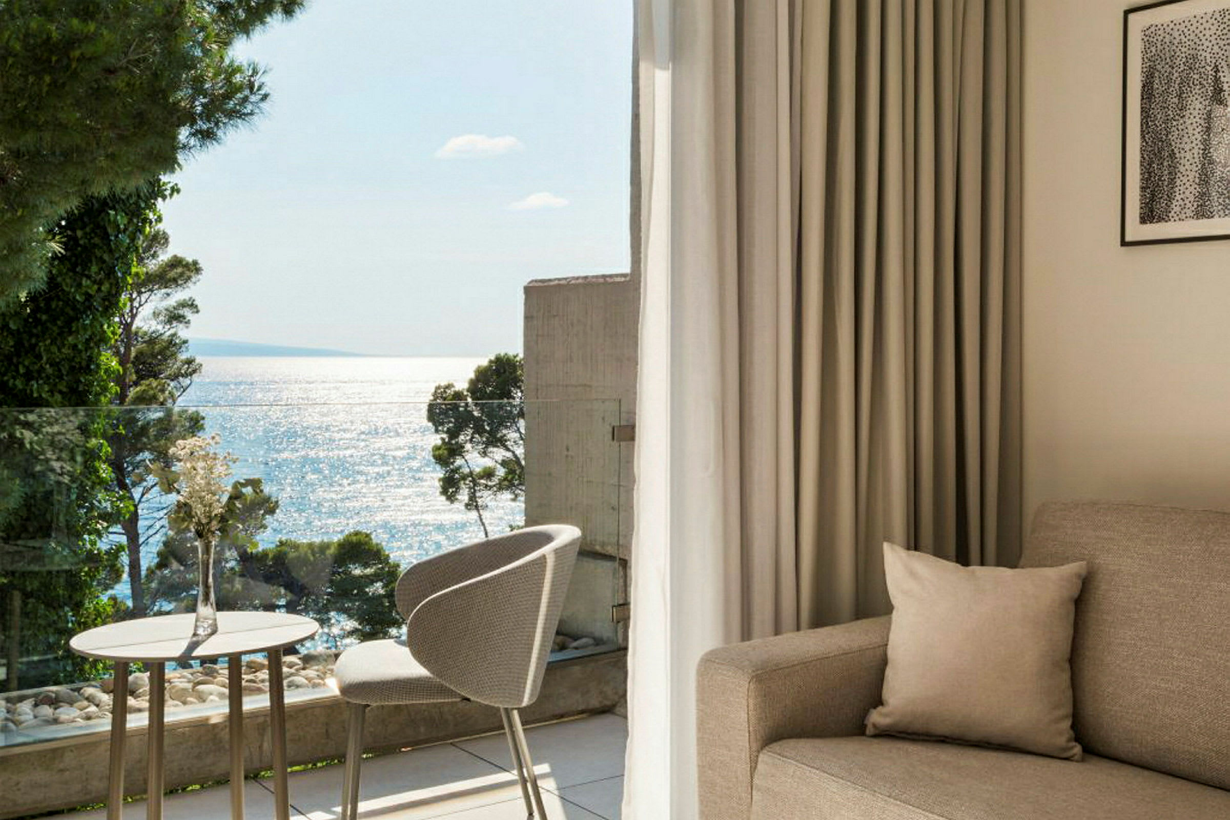 Ljus och modern hotellrum med havsutsikt från balkongen. (AI-genererad text)