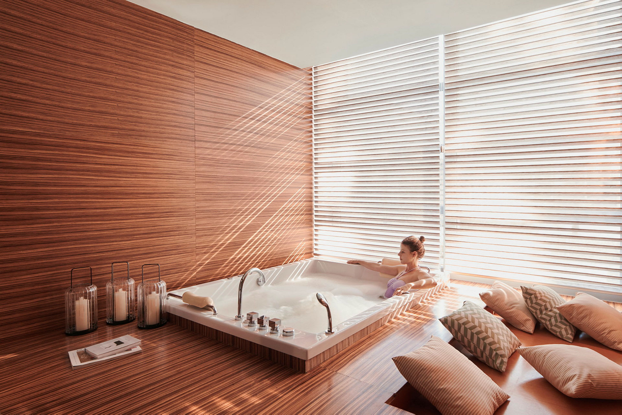 Ett modernt badrum med en jacuzzi omgiven av träpaneler och dekorativa kuddar. (AI-genererad text)