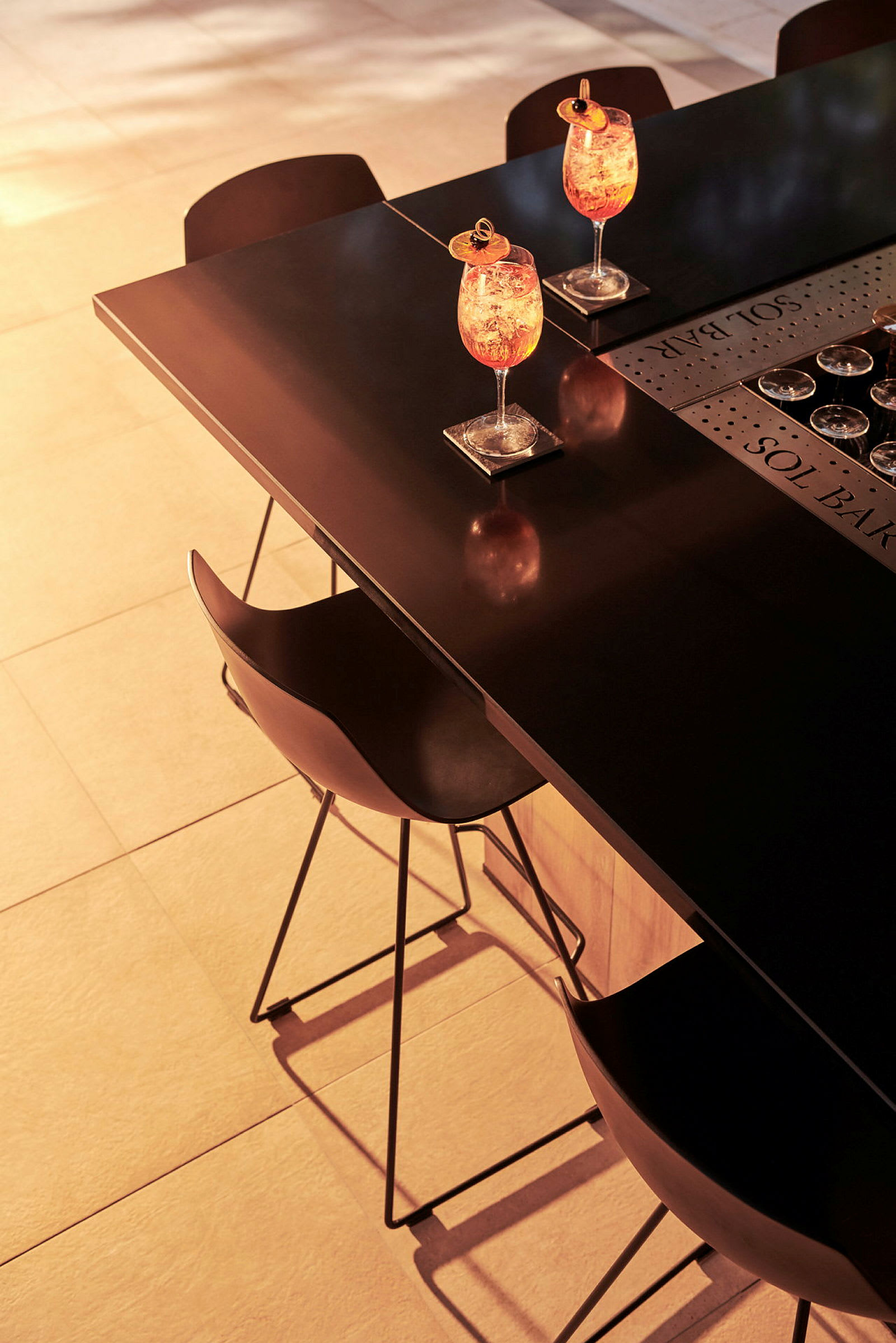 Två cocktails på ett bord med stolar i kvällsljus. (AI-genererad text)