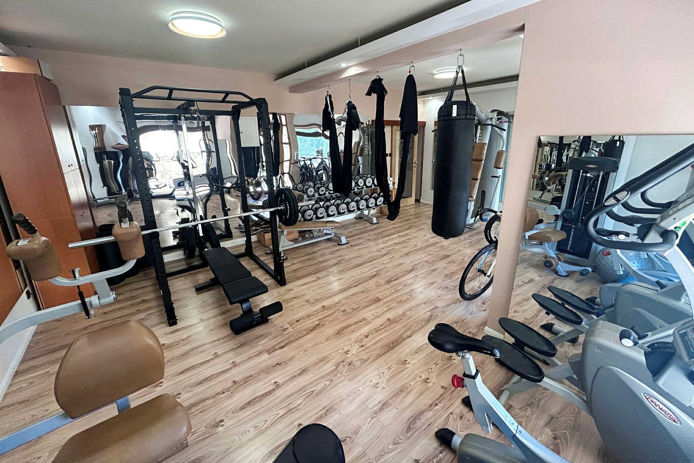 Bild av ett gym med träningsutrustning som vikter, löpmaskiner och punching bag. (AI-genererad text)