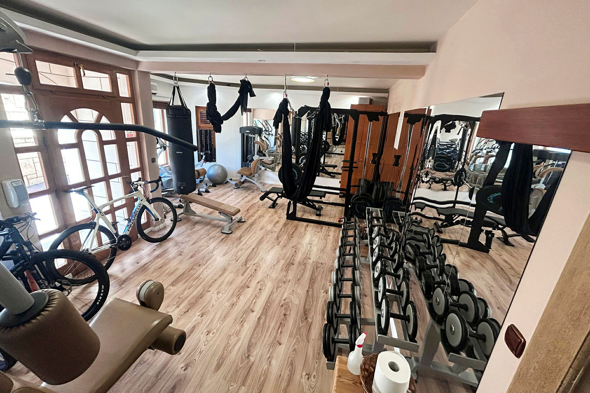 Ett gym med träningsutrustning som hantlar, cyklar och maskiner. (AI-genererad text)