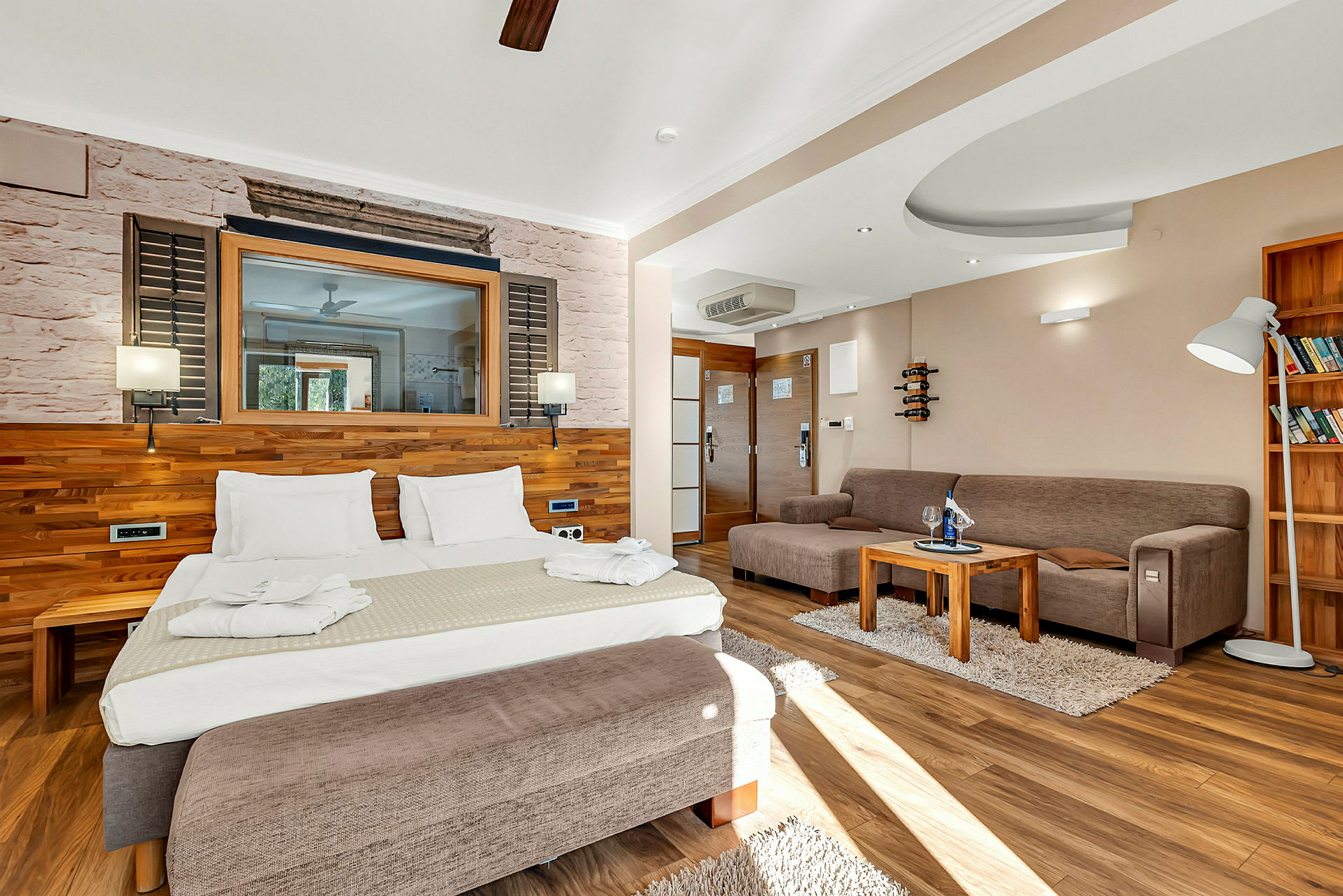 Hotellrum med säng, soffa och bord. (AI-genererad text)