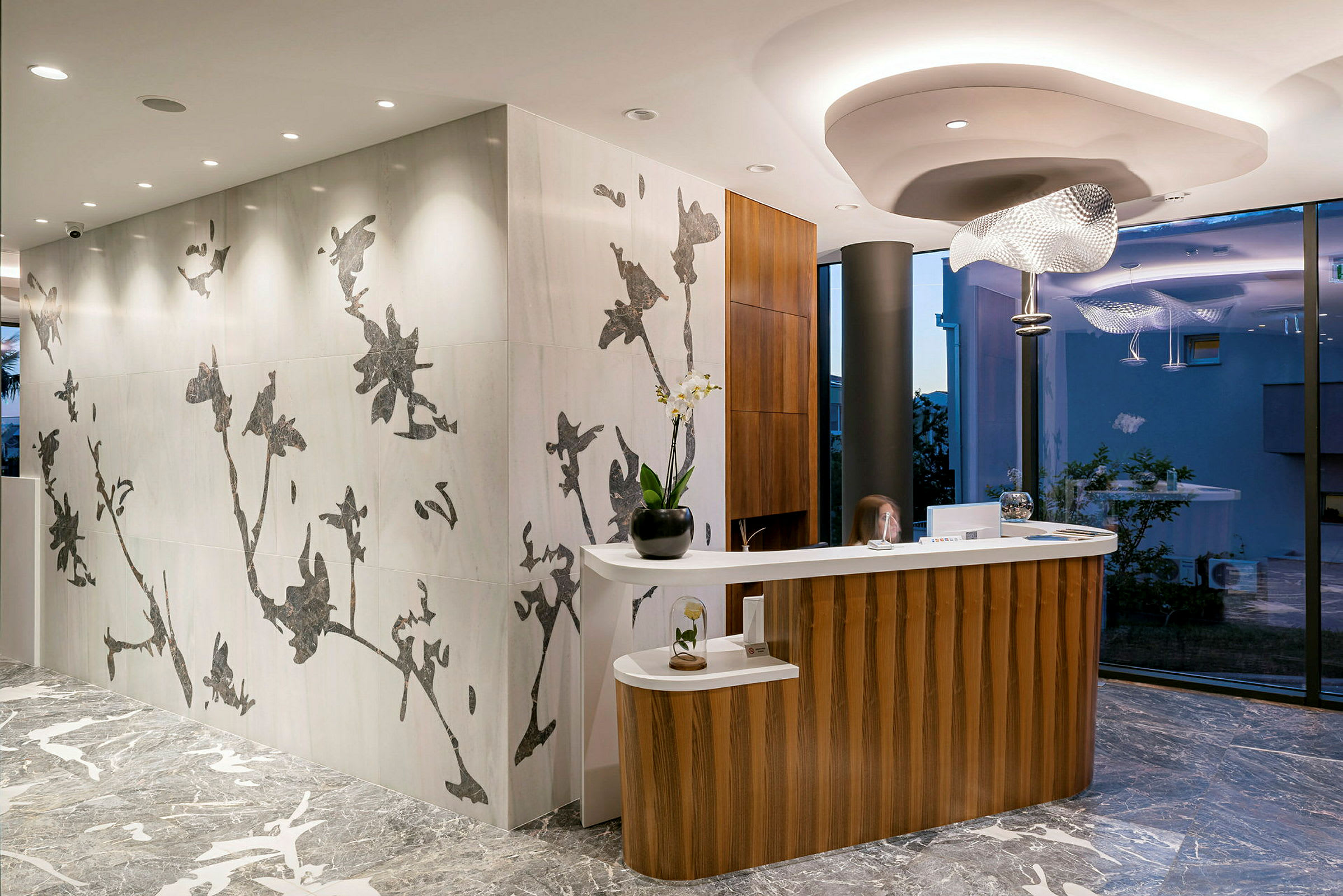 Receptionen i en modern interiör med trägolv och väggar dekorerade med blommönster. (AI-genererad text)