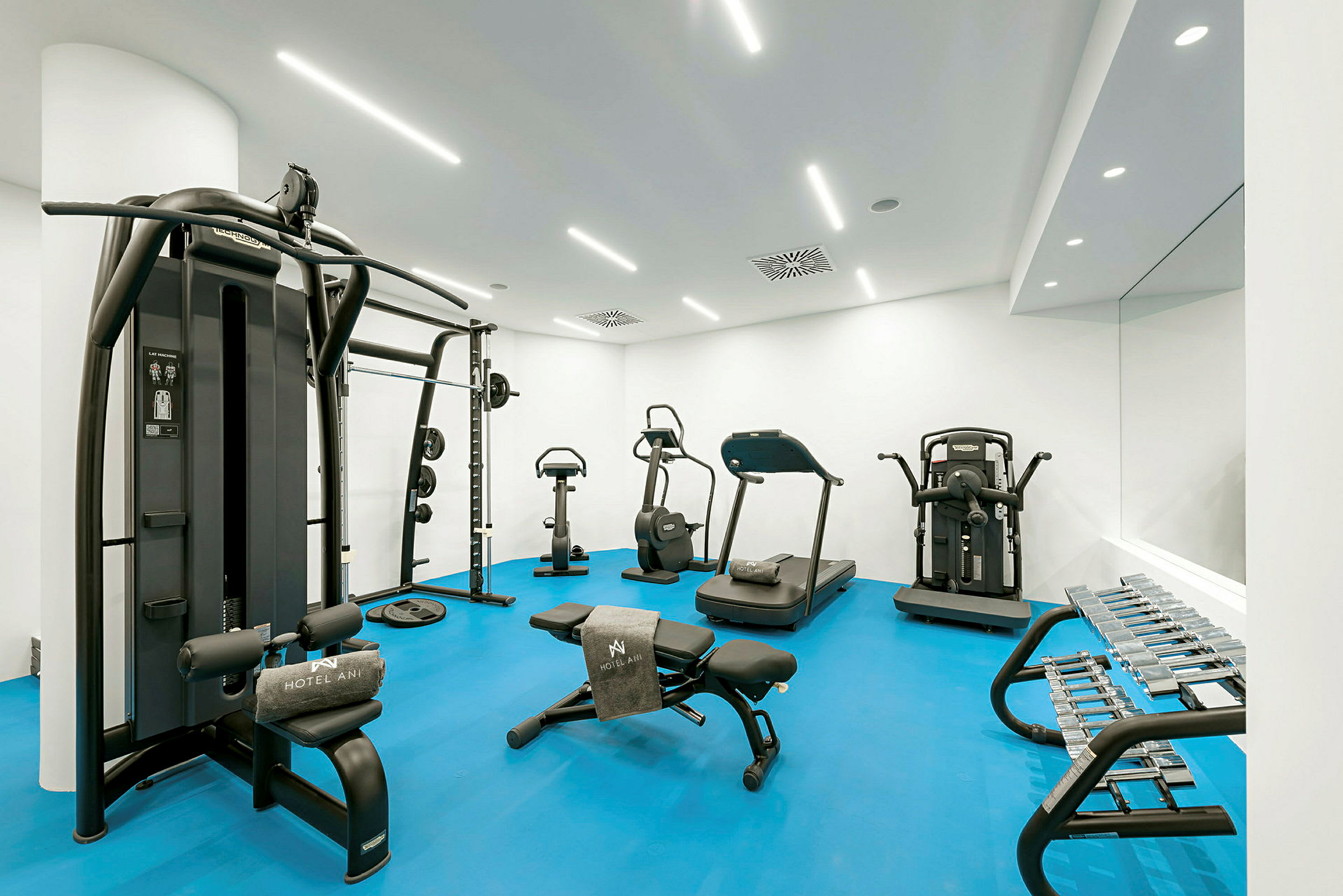 Gym med träningsutrustning, inklusive löpband, motionscyklar och hantlar. (AI-genererad text)