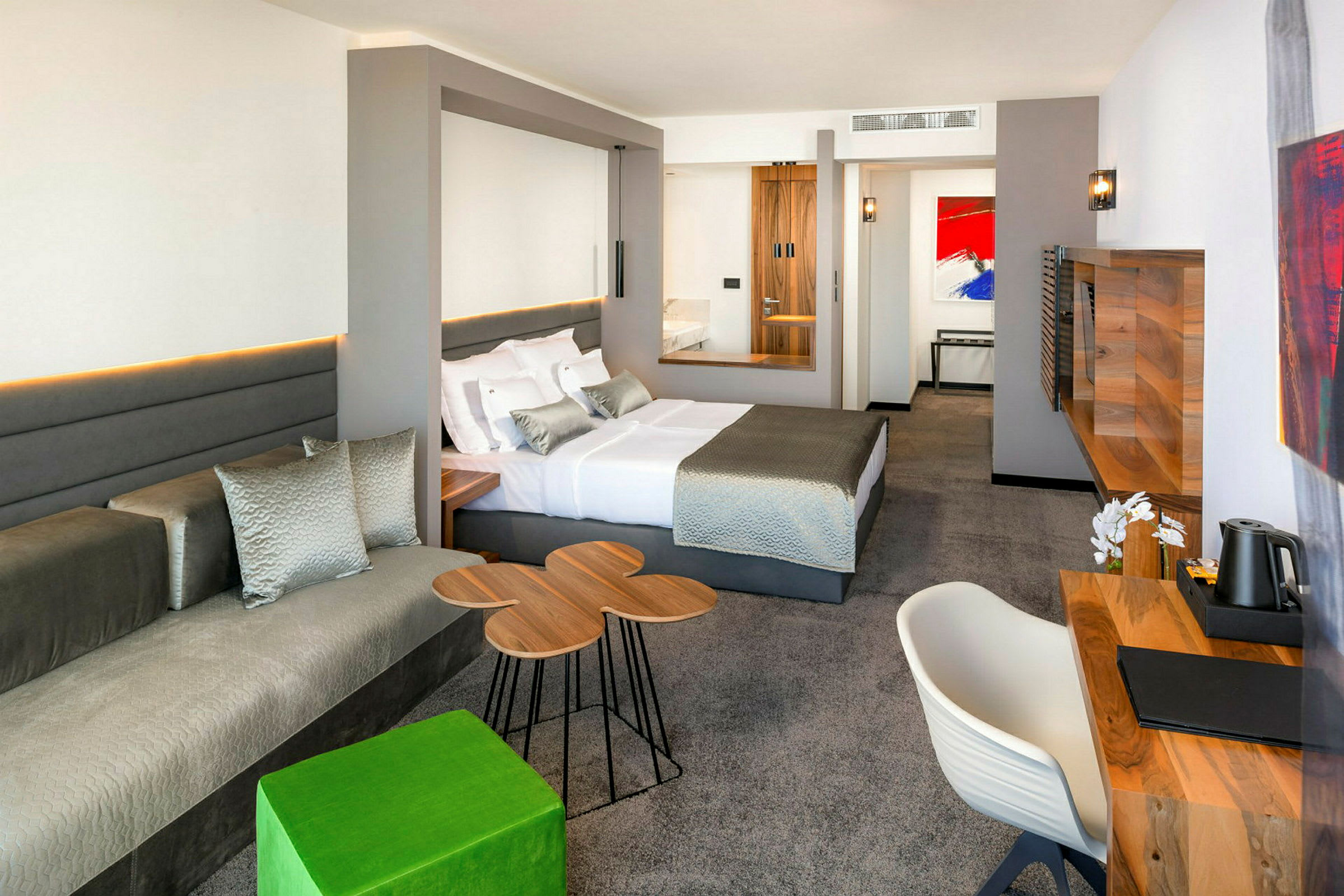 Modernt hotellrum med en stor säng, skrivbord och sittgrupp. (AI-genererad text)