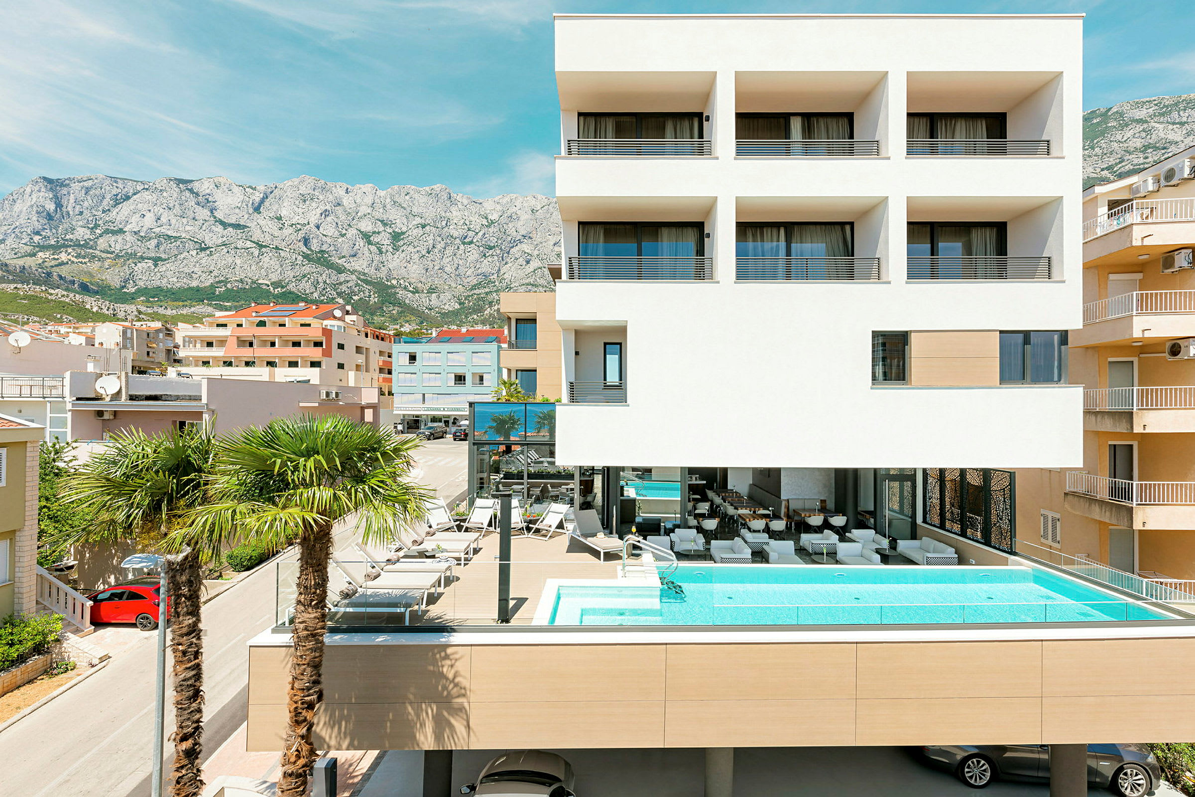 Modern byggnad med pool och palmer framför. (AI-genererad text)
