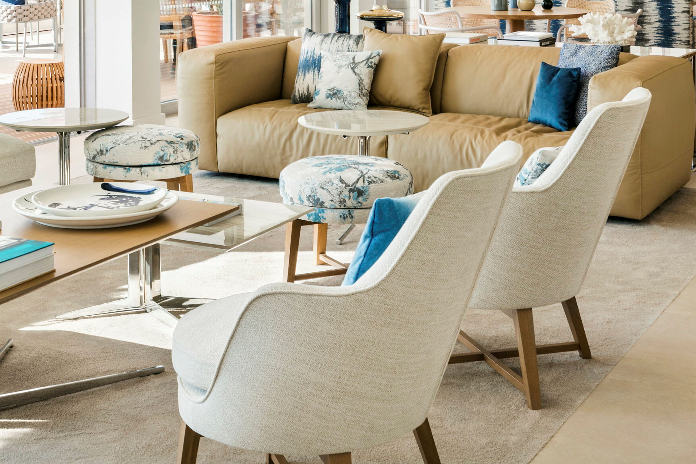 Ett modernt vardagsrum med en beige soffa, två vita fåtöljer och ett soffbord. (AI-genererad text)