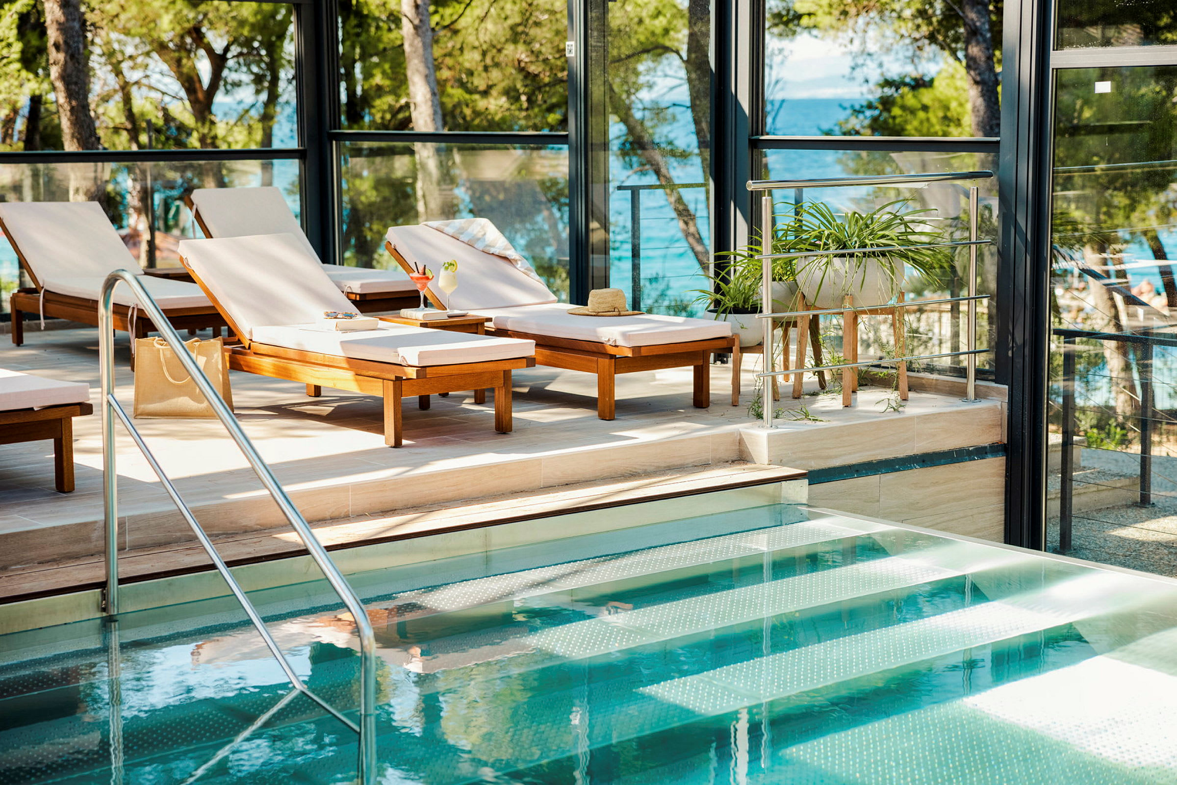 Solstolar vid en pool med utsikt mot havet. (AI-genererad text)