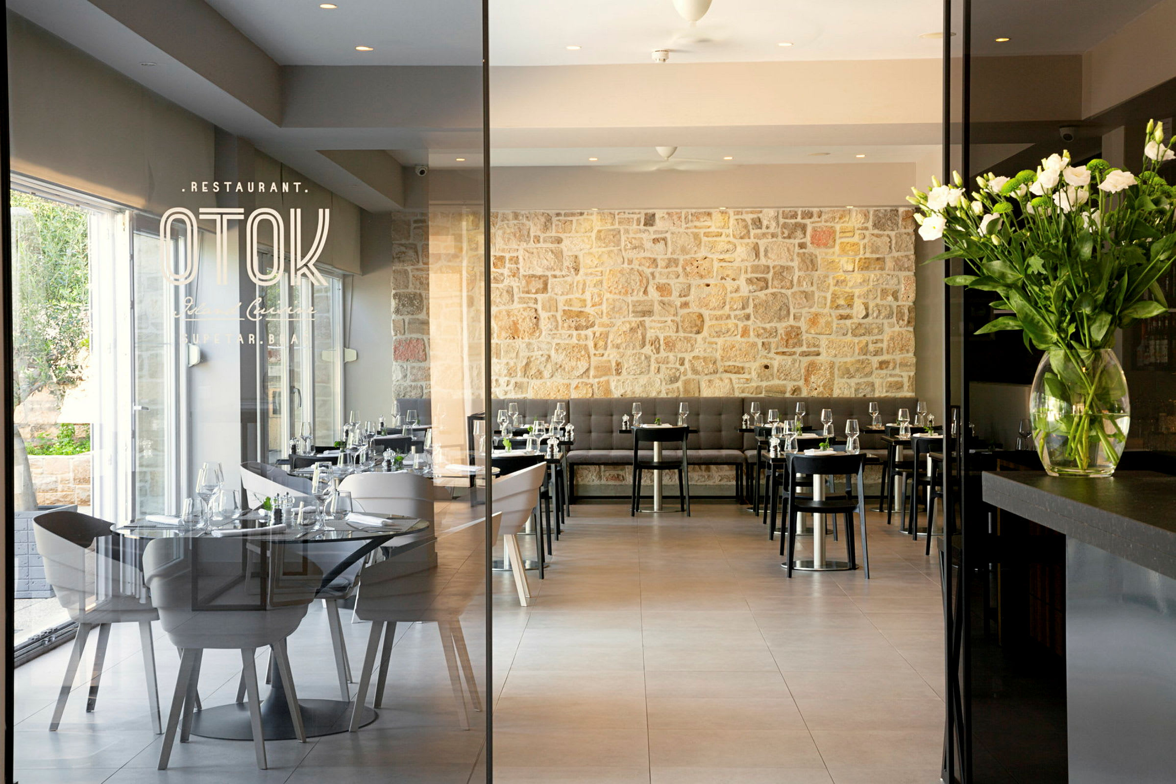 En restaurang med moderna möbler och stenvägg. (AI-genererad text)