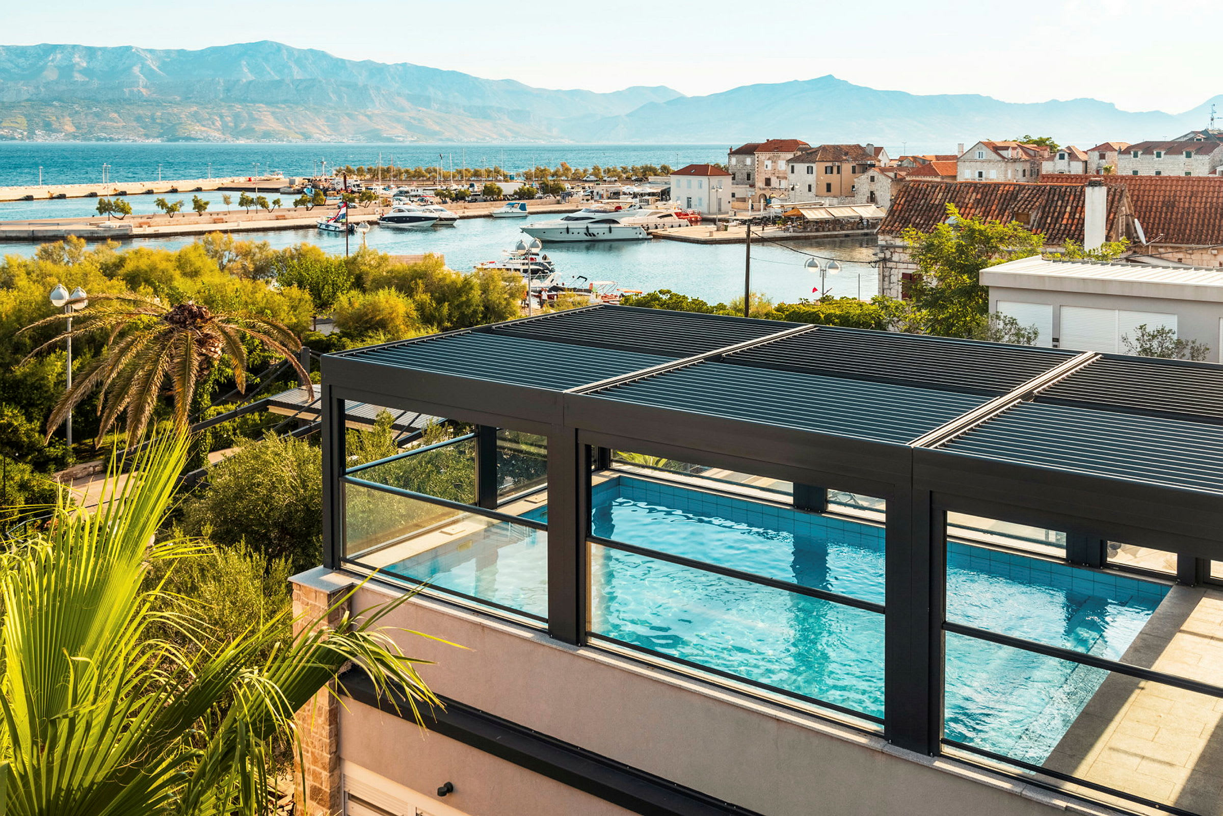 Takterrasspool med utsikt över hamn och berg. (AI-genererad text)