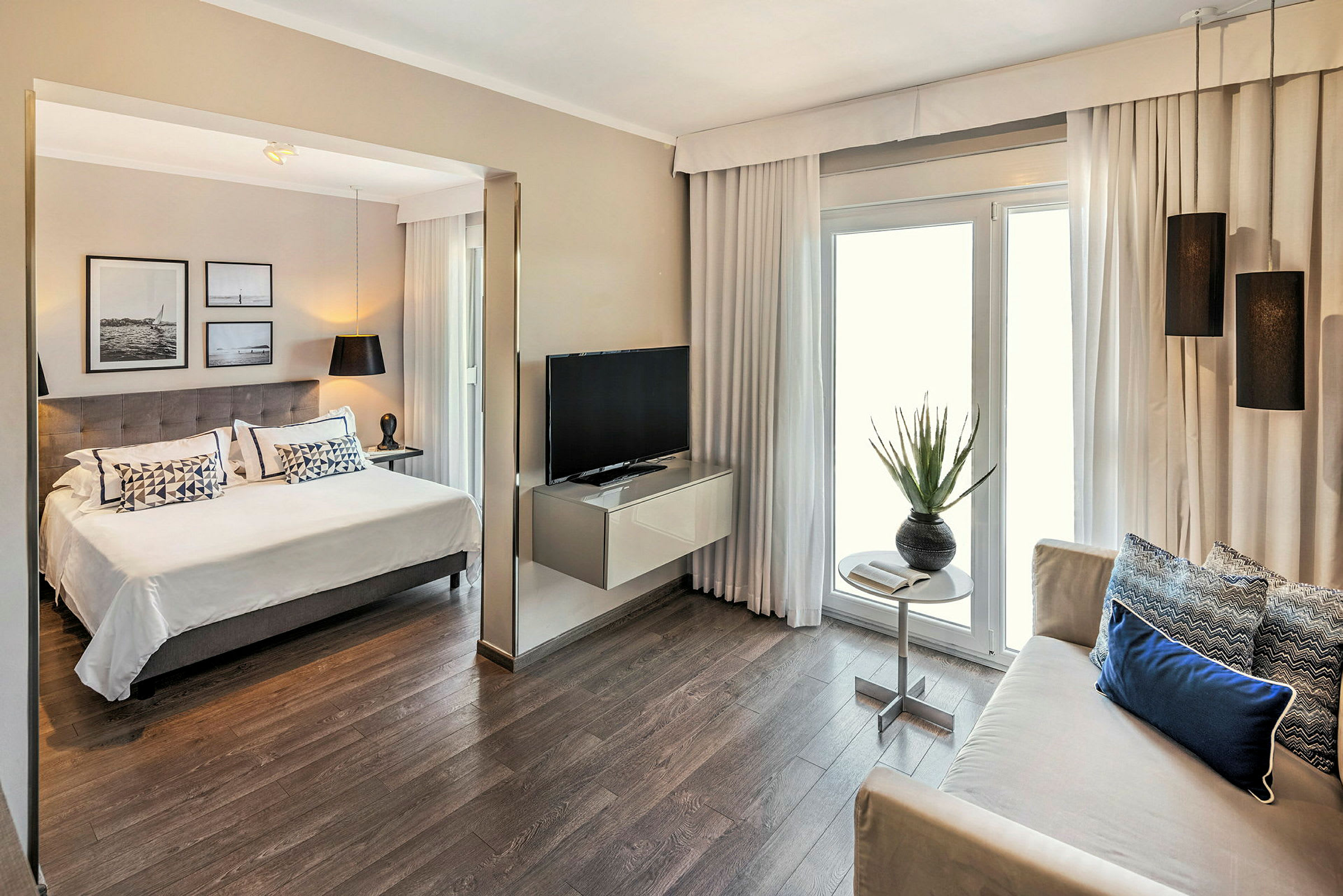 Bild på ett modernt hotellrum med en dubbelsäng, sittgrupp, TV och inredningsdetaljer. (AI-genererad text)