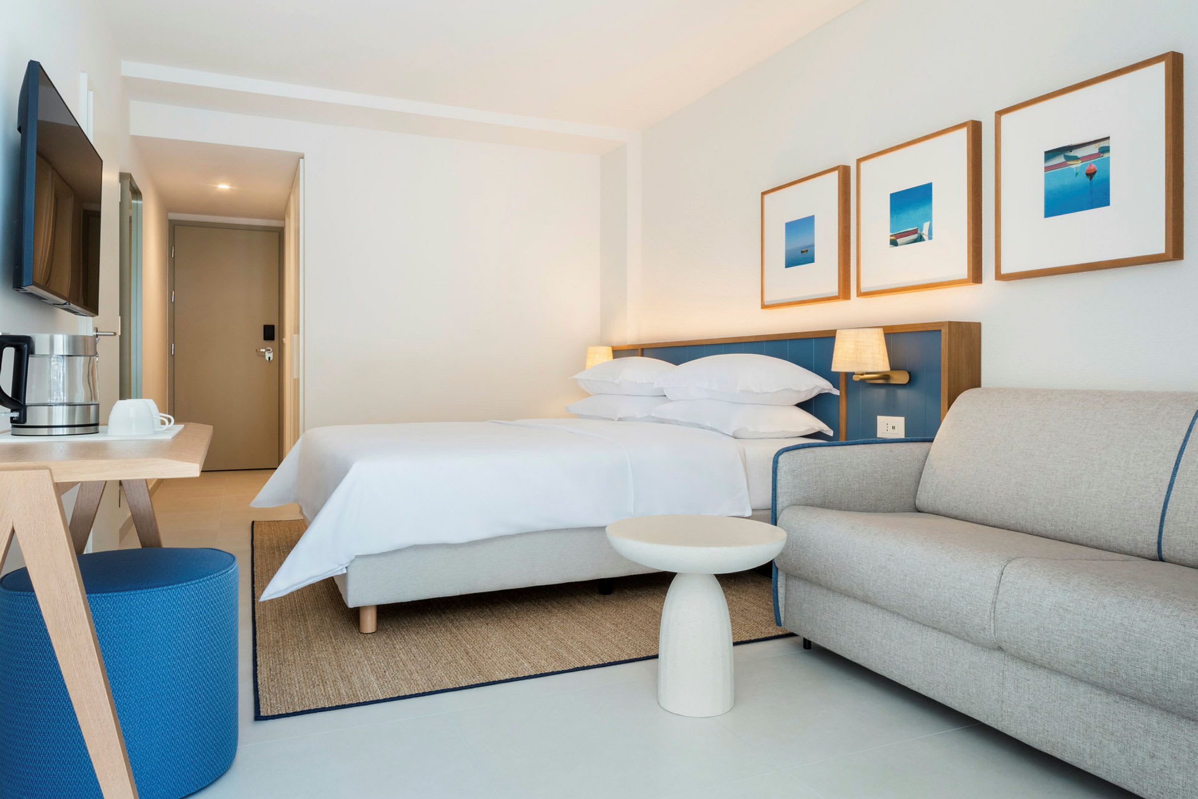 Hotellrum med säng, soffa och bord. (AI-genererad text)