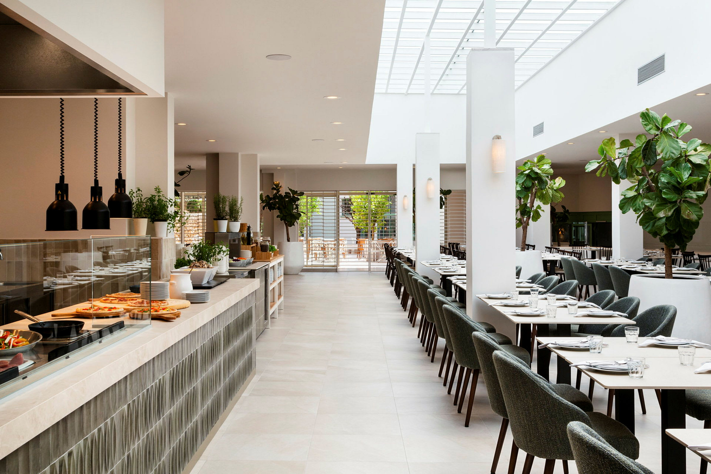 Ljus och modern restauranginteriör med matbord, stolar och ett serveringsområde. (AI-genererad text)