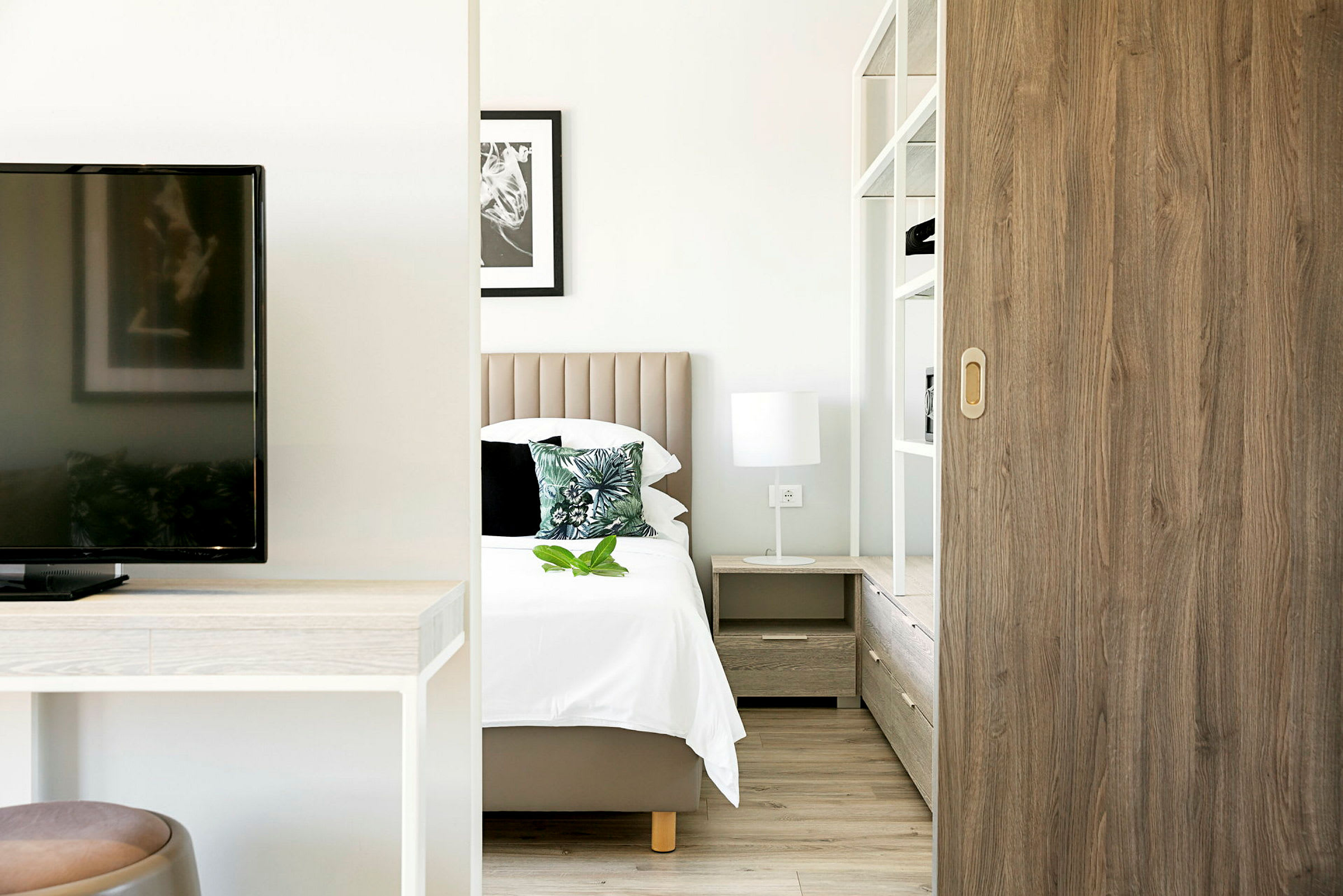 En modern hotellrumsmiljö med säng, sängbord och inredning. (AI-genererad text)