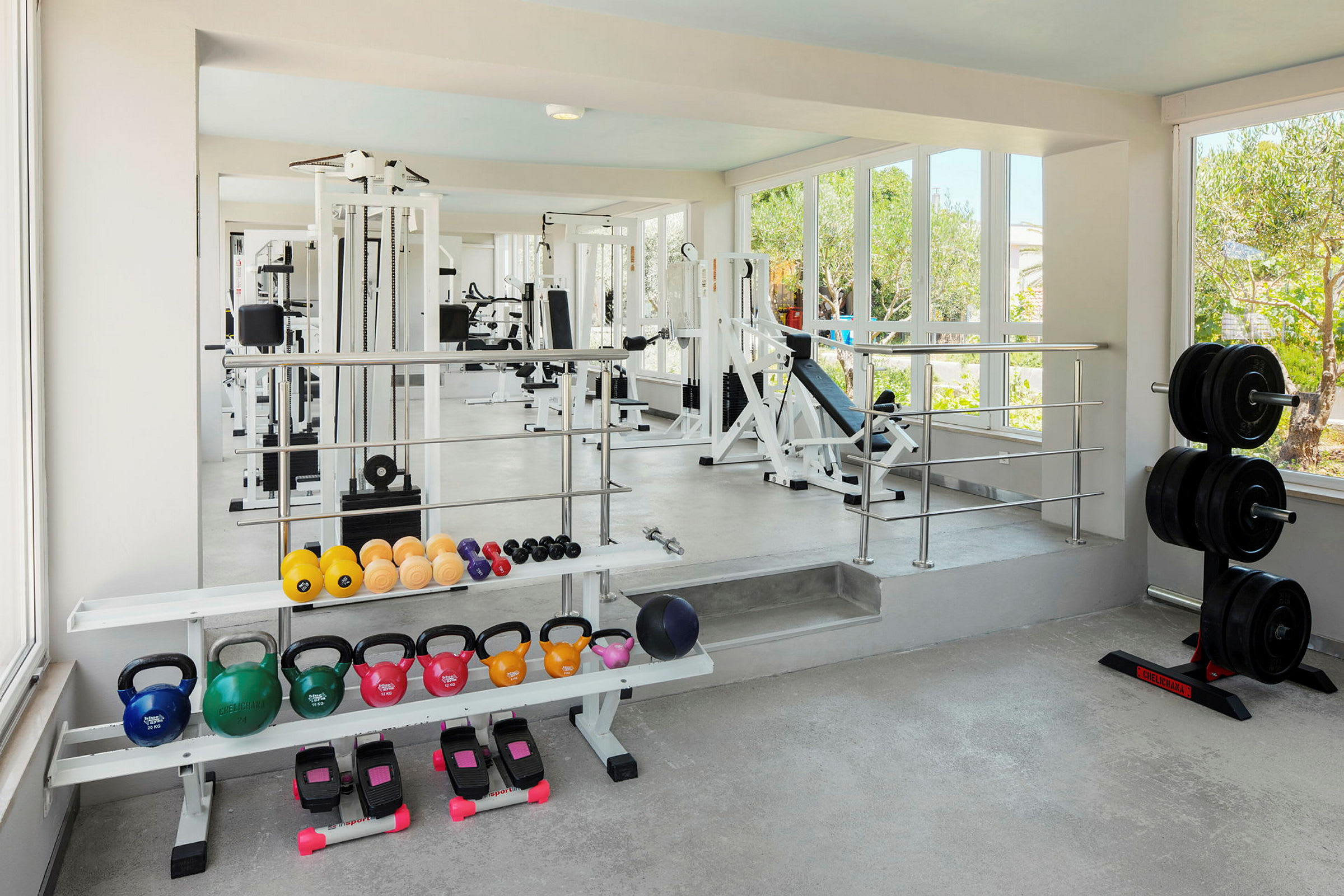 Ett gym med olika träningsmaskiner, fria vikter och kettlebells. (AI-genererad text)
