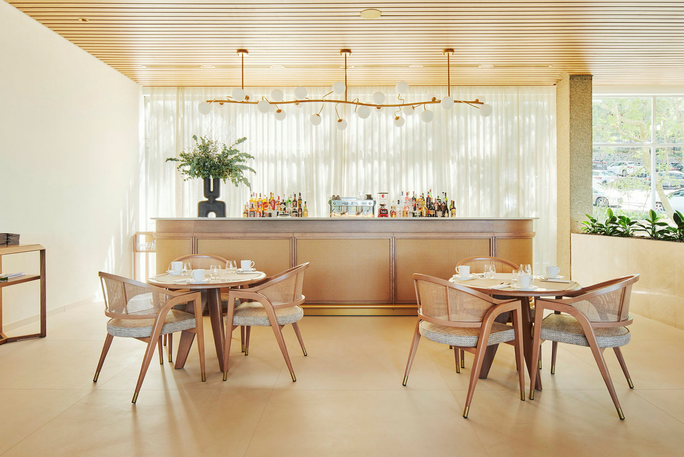 Bild av en ljus restauranginteriör med träbord, stolar och en bardisk. (AI-genererad text)