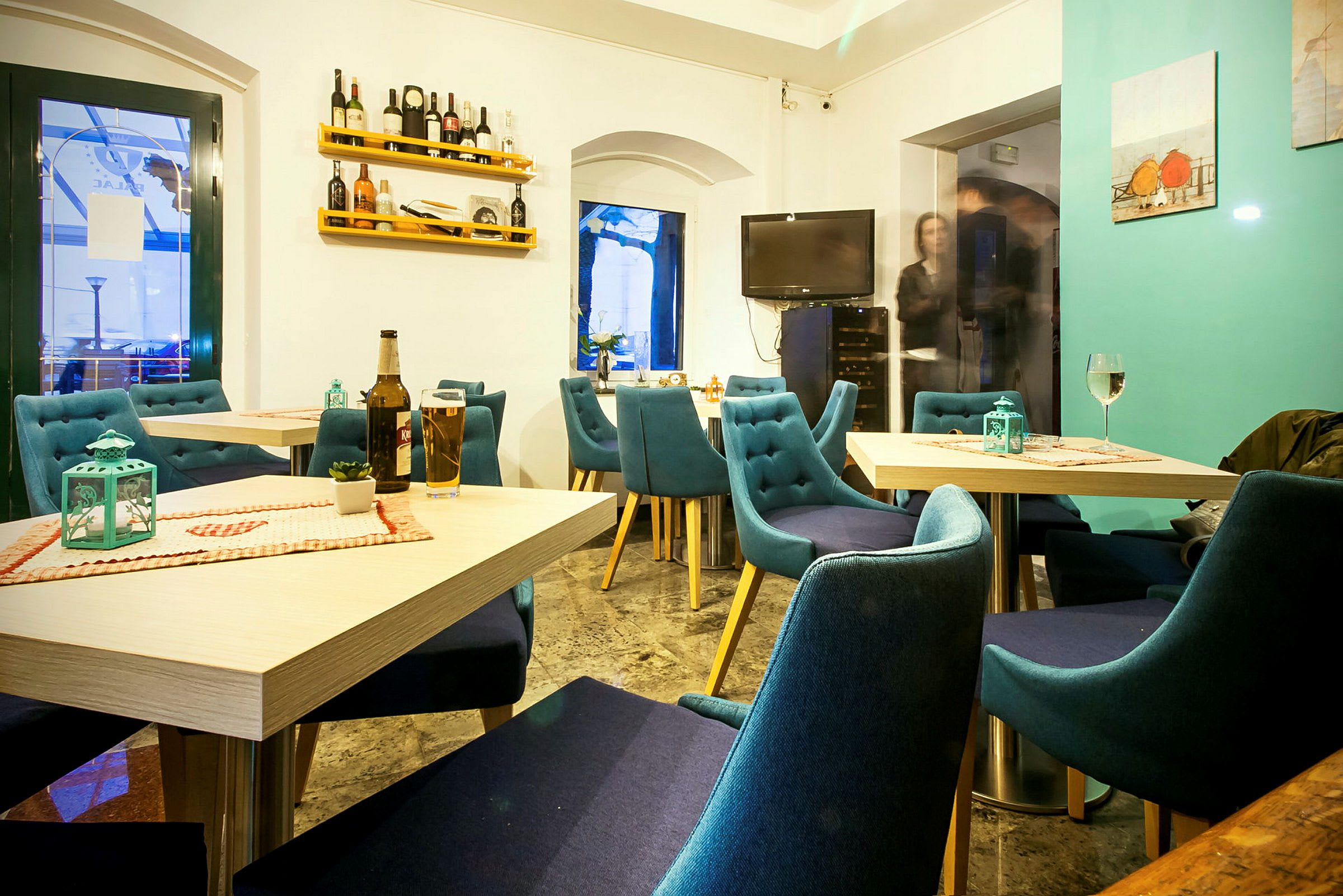 En ljus och mysig restaurang med blå stolar och dukade bord. (AI-genererad text)