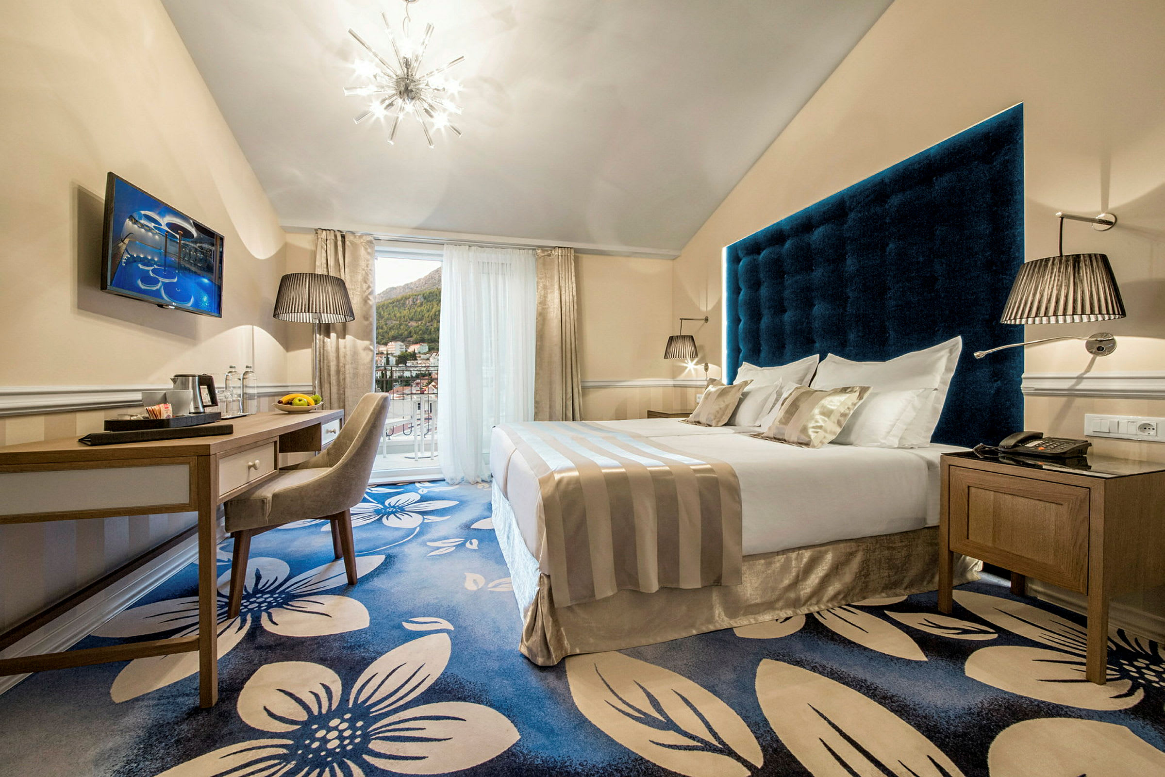 Hotellrum med dubbelbädd och blå blommigt golv. (AI-genererad text)