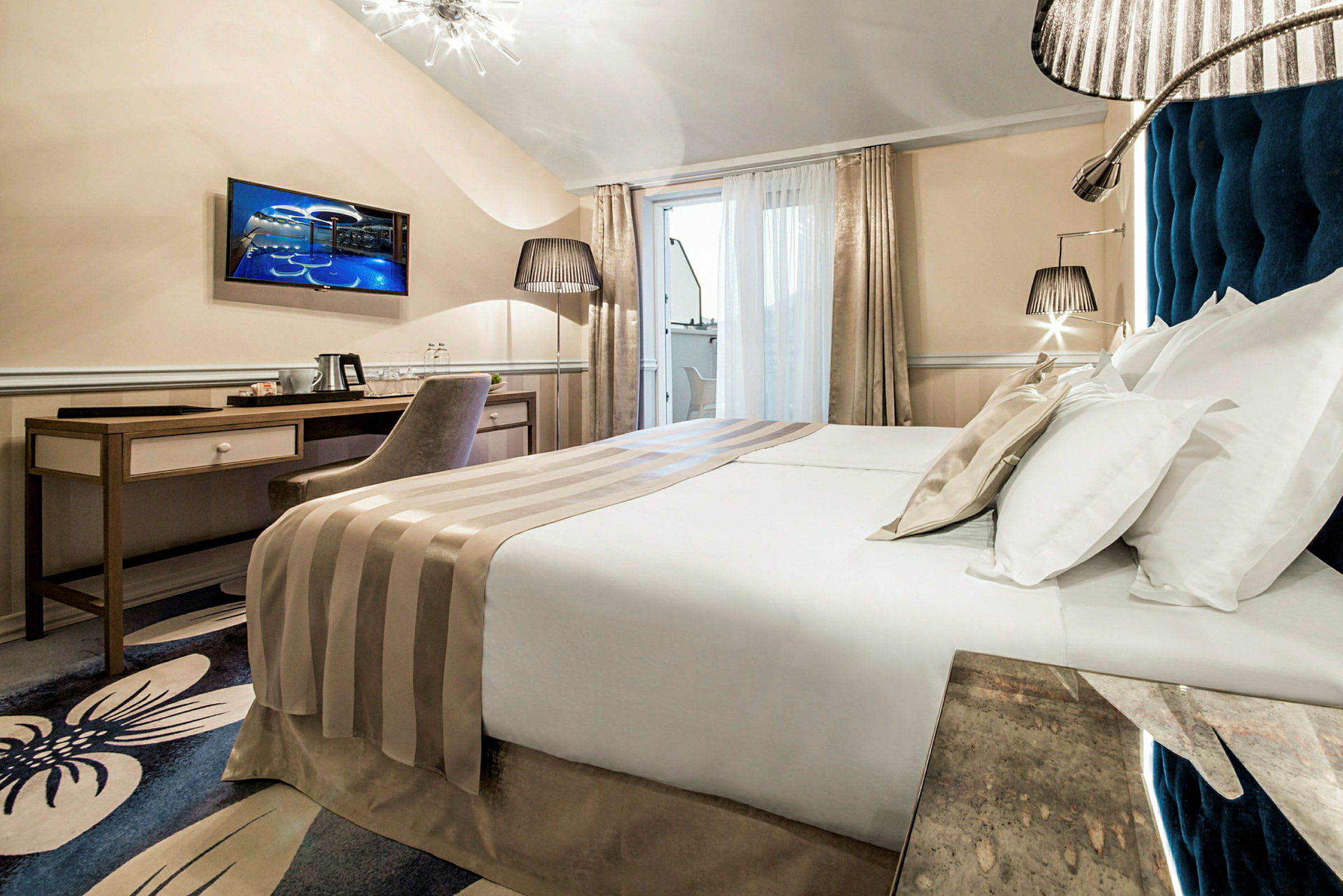 Modern hotellrum med dubbelsäng, skrivbord, stol och TV. (AI-genererad text)
