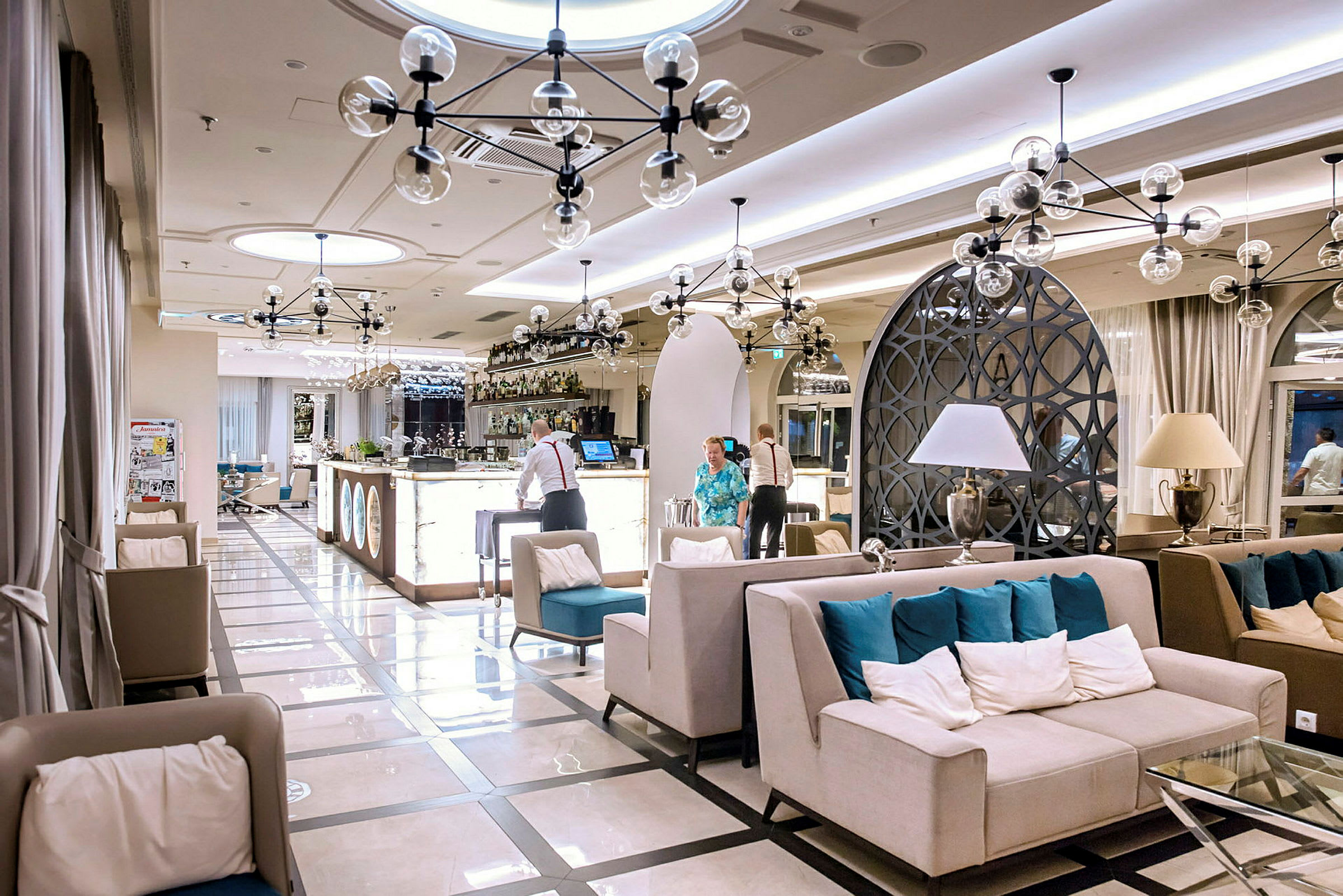 Elegant hotellobby med sittgrupper och en välbelyst bar. (AI-genererad text)