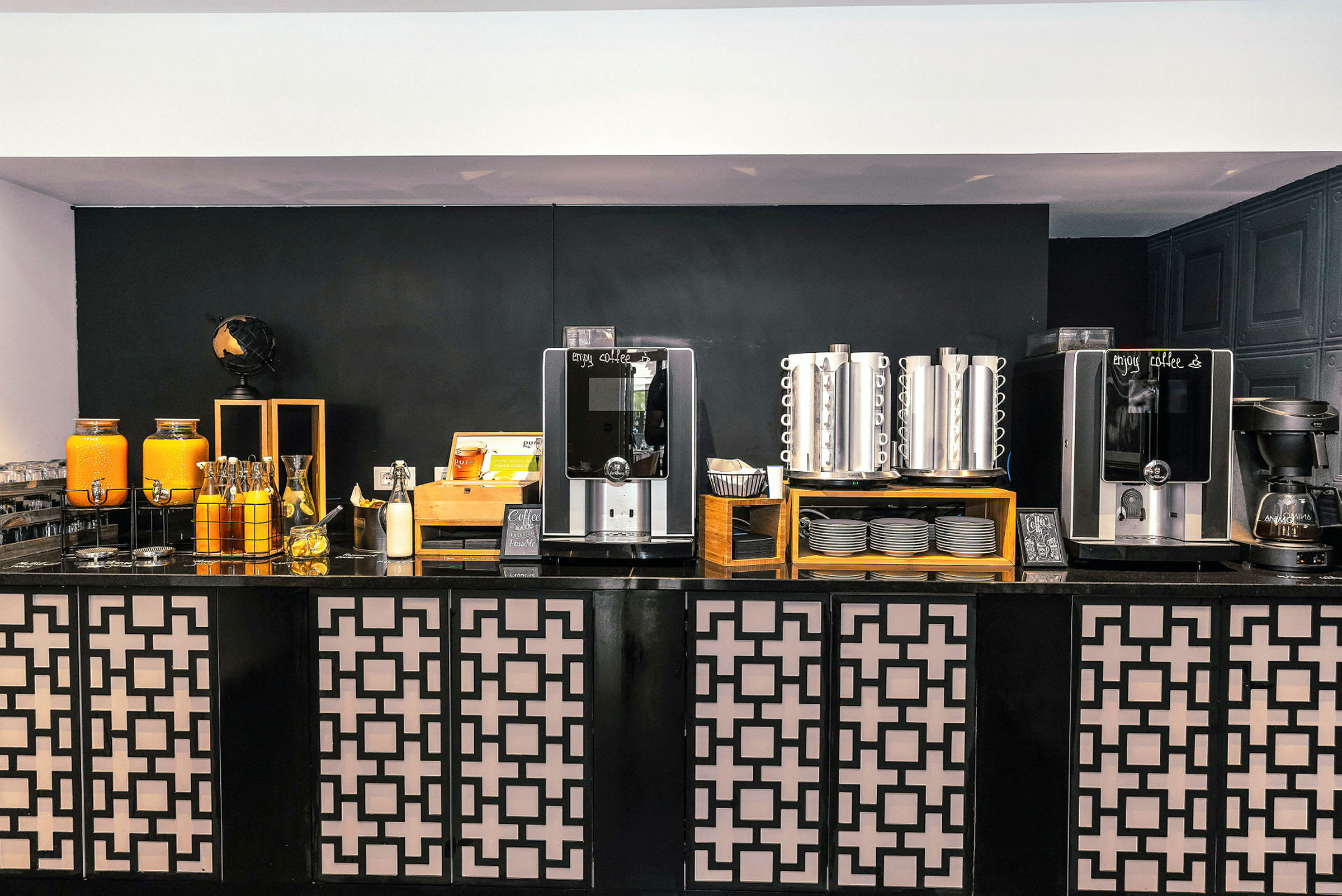 Bild av en kaffestation med automater, termobehållare och juicebehållare. (AI-genererad text)