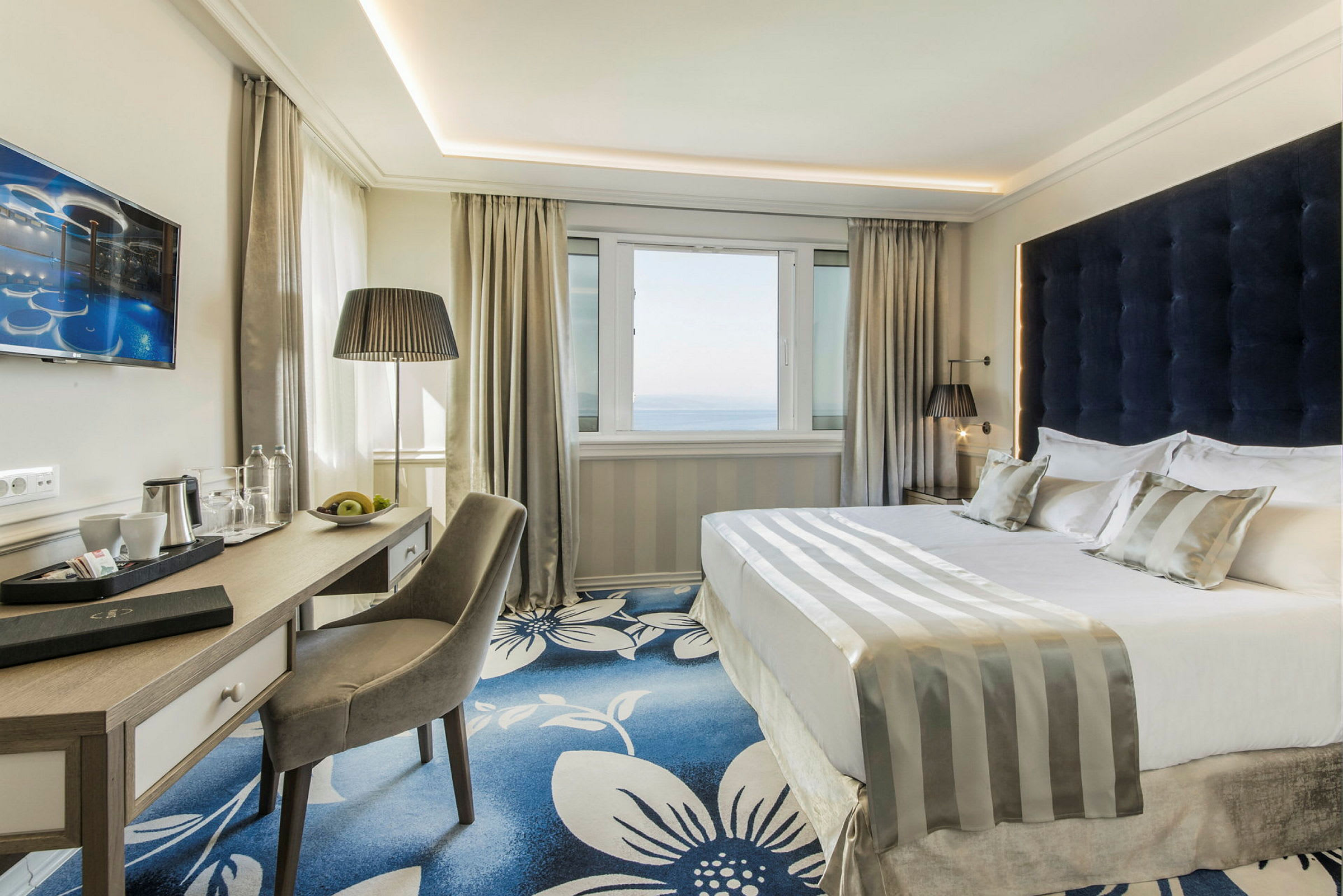 Ett modernt hotellrum med en dubbelsäng och skrivbord. (AI-genererad text)