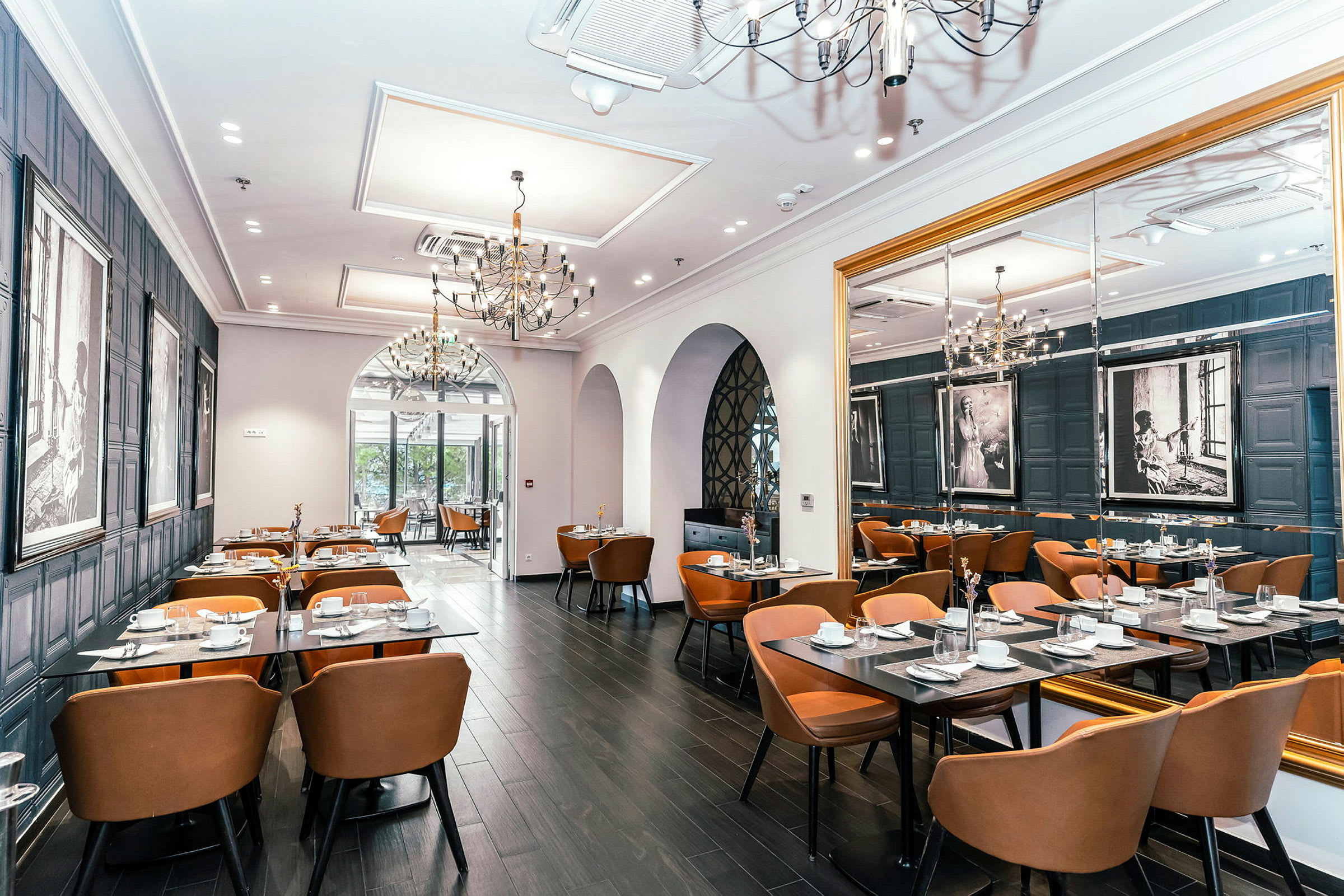 Interiör av en elegant restaurang med bord och stolar, dekorerad med konst på väggarna. (AI-genererad text)