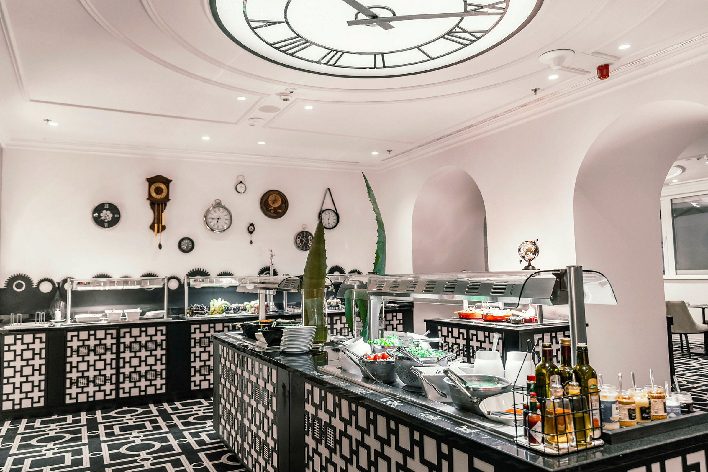 Ett bufféområde i en restaurang, med en dekorativ inredning och bord som serverar olika maträtter. (AI-genererad text)