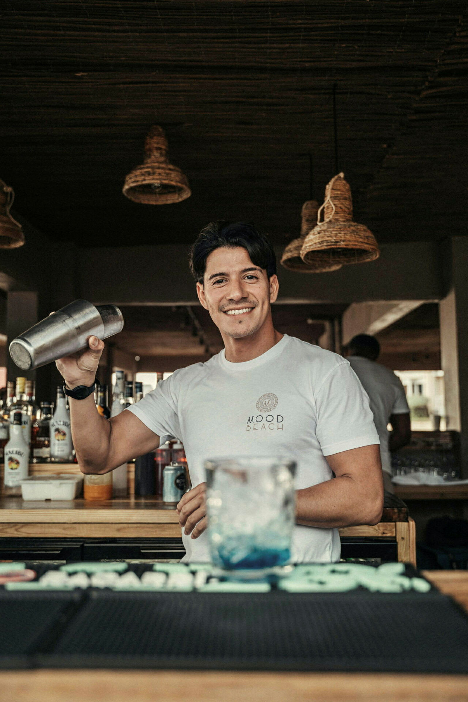 En bartender håller i en cocktailskakare bakom en bardisk. (AI-genererad text)