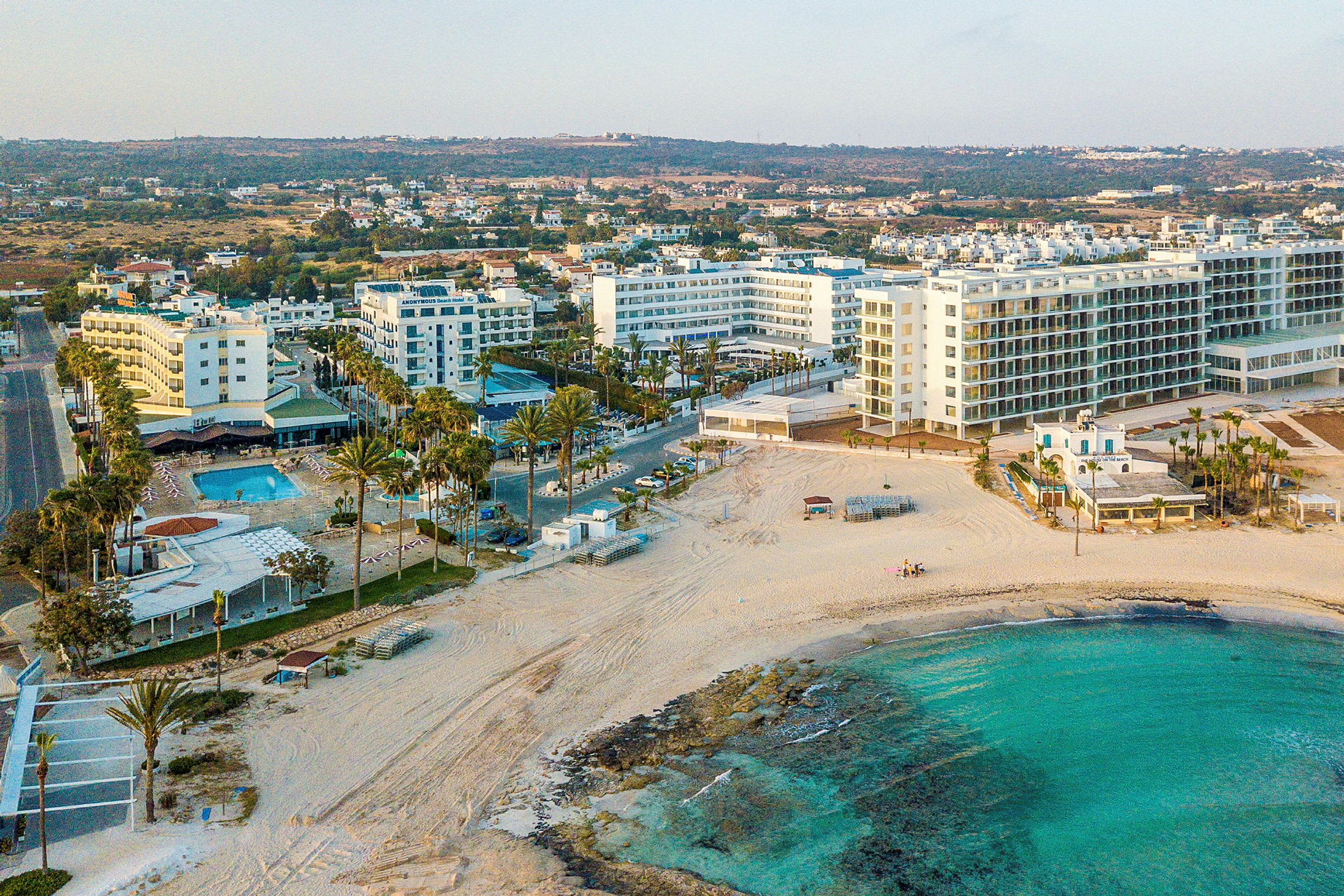 Vy över flera hotellbyggnader vid en strand. (AI-genererad text)