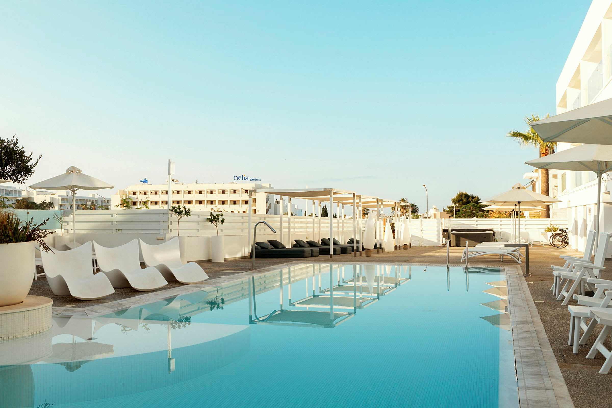 Utomhuspool med solstolar och parasoller vid hotellet. (AI-genererad text)